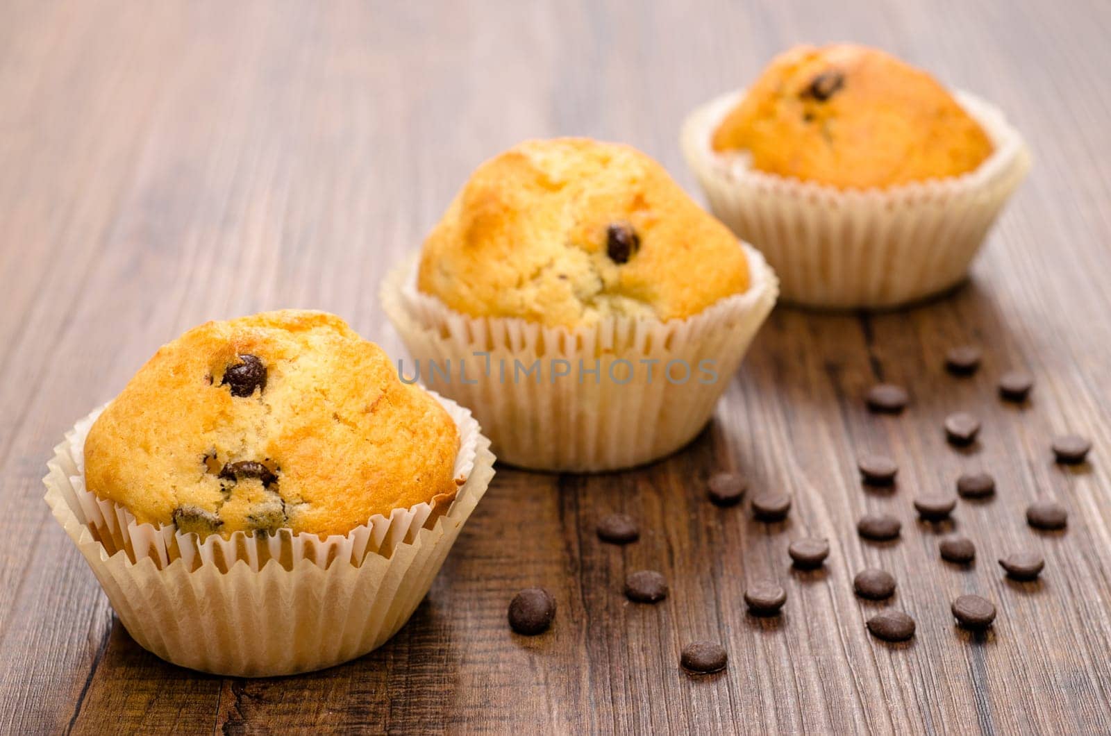 Three muffins with chocolate and banana on one table