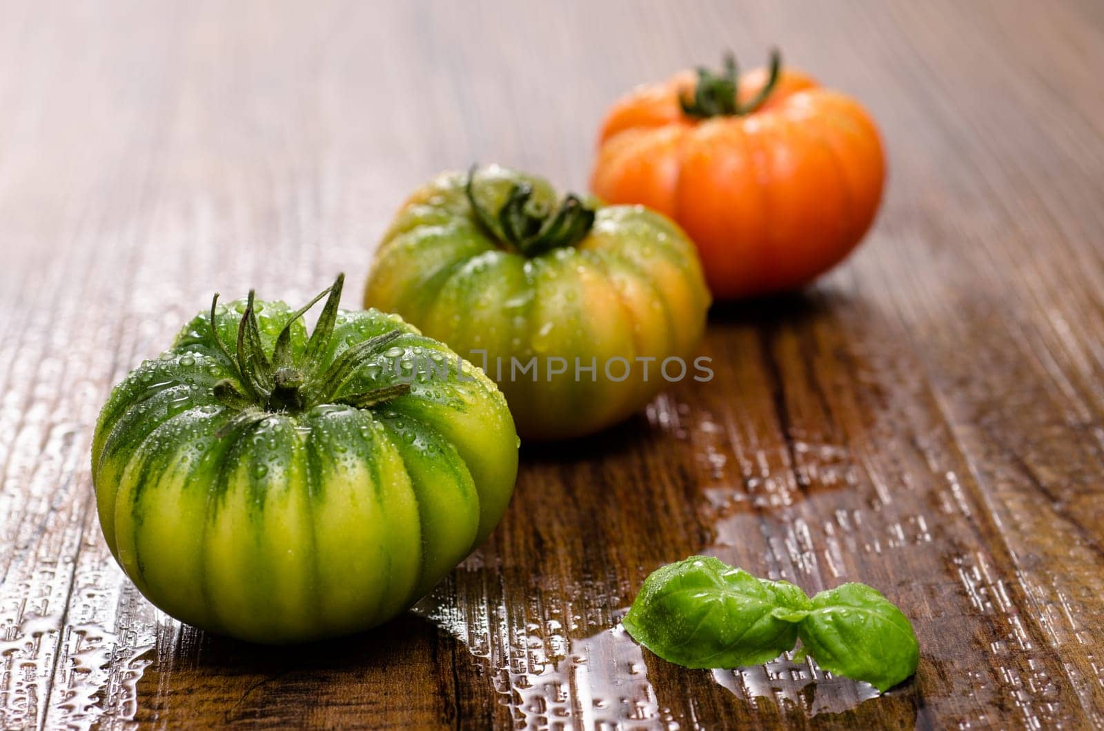 Italian ox heart tomatoes with basil on a wooden table
