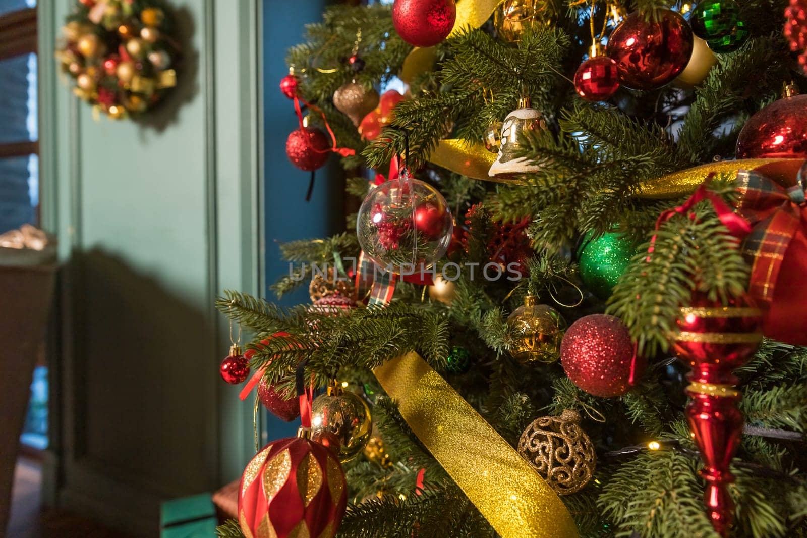 Stylish Christmas minimalist interior. Comfort home with fireplace. Gifts boxes under Christmas tree with decorations red balls in white living room.