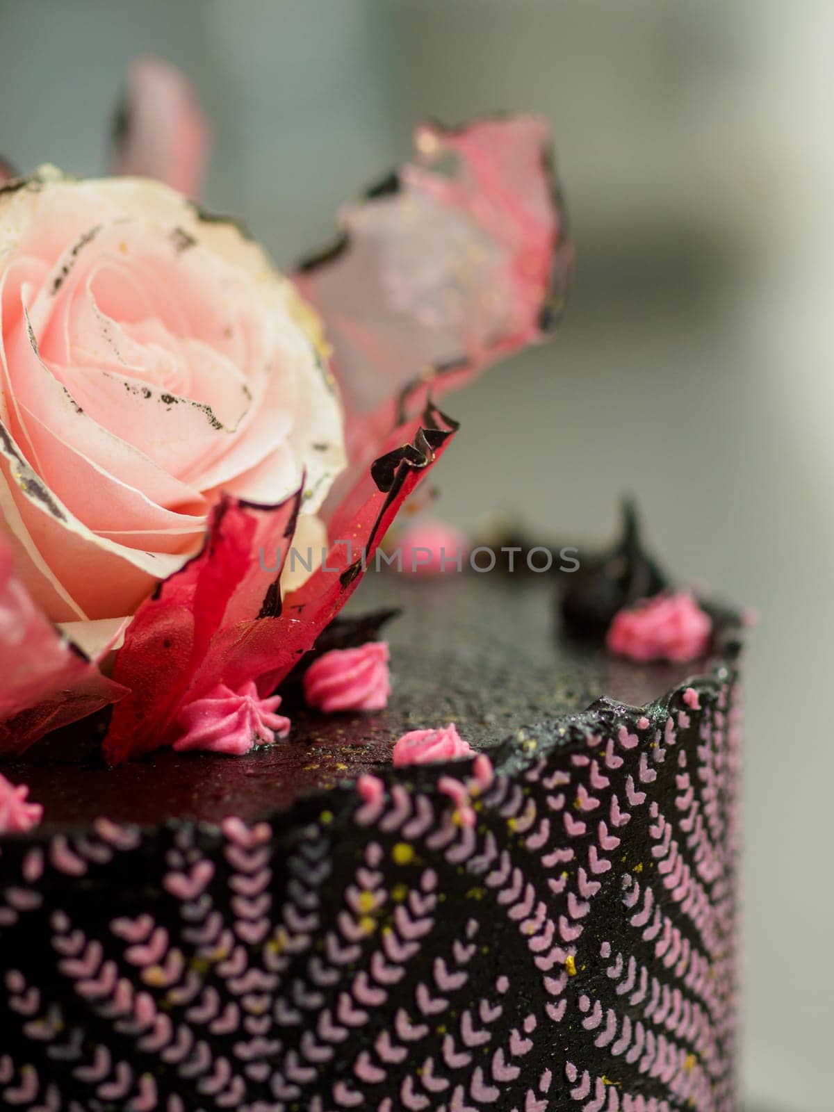 frosted icing black decorate cake for birthday celebration, real rose topping and pink sweet swirls by verbano