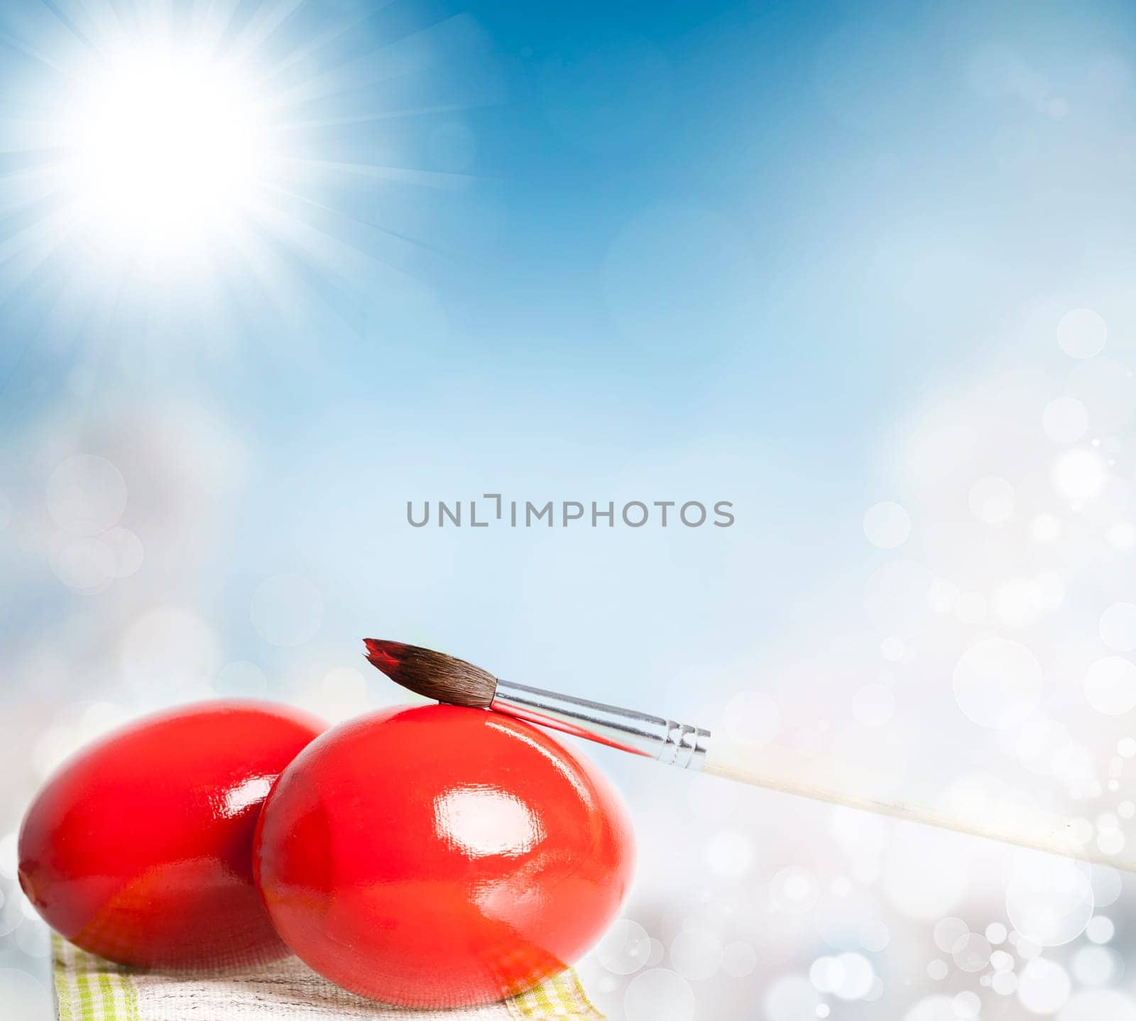 Easter eggs and paint brush on spring bokeh background