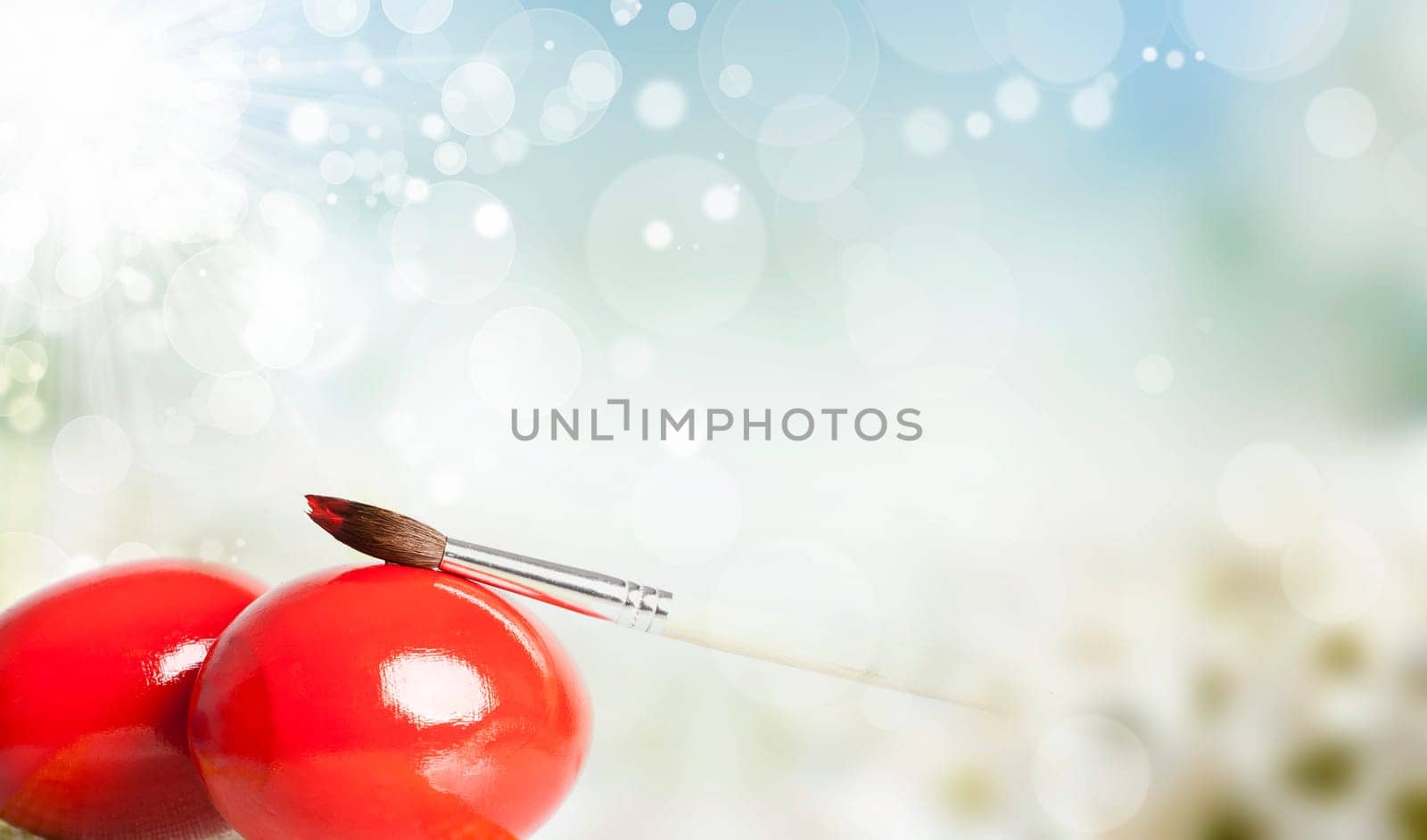 Easter eggs and paint brush on spring bokeh background