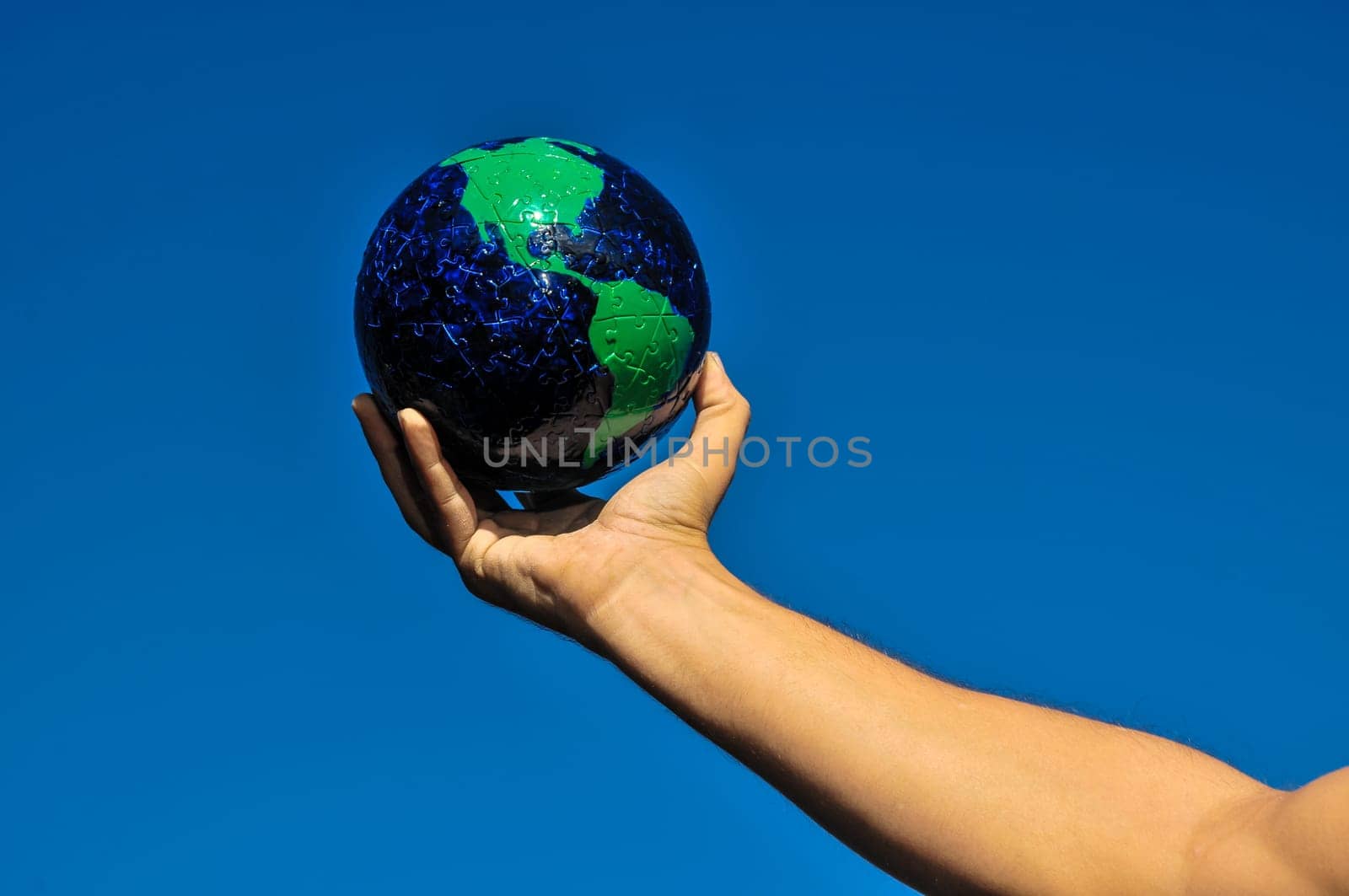 Vintage Old Globe Earth and Human Hand over a Blue Sky