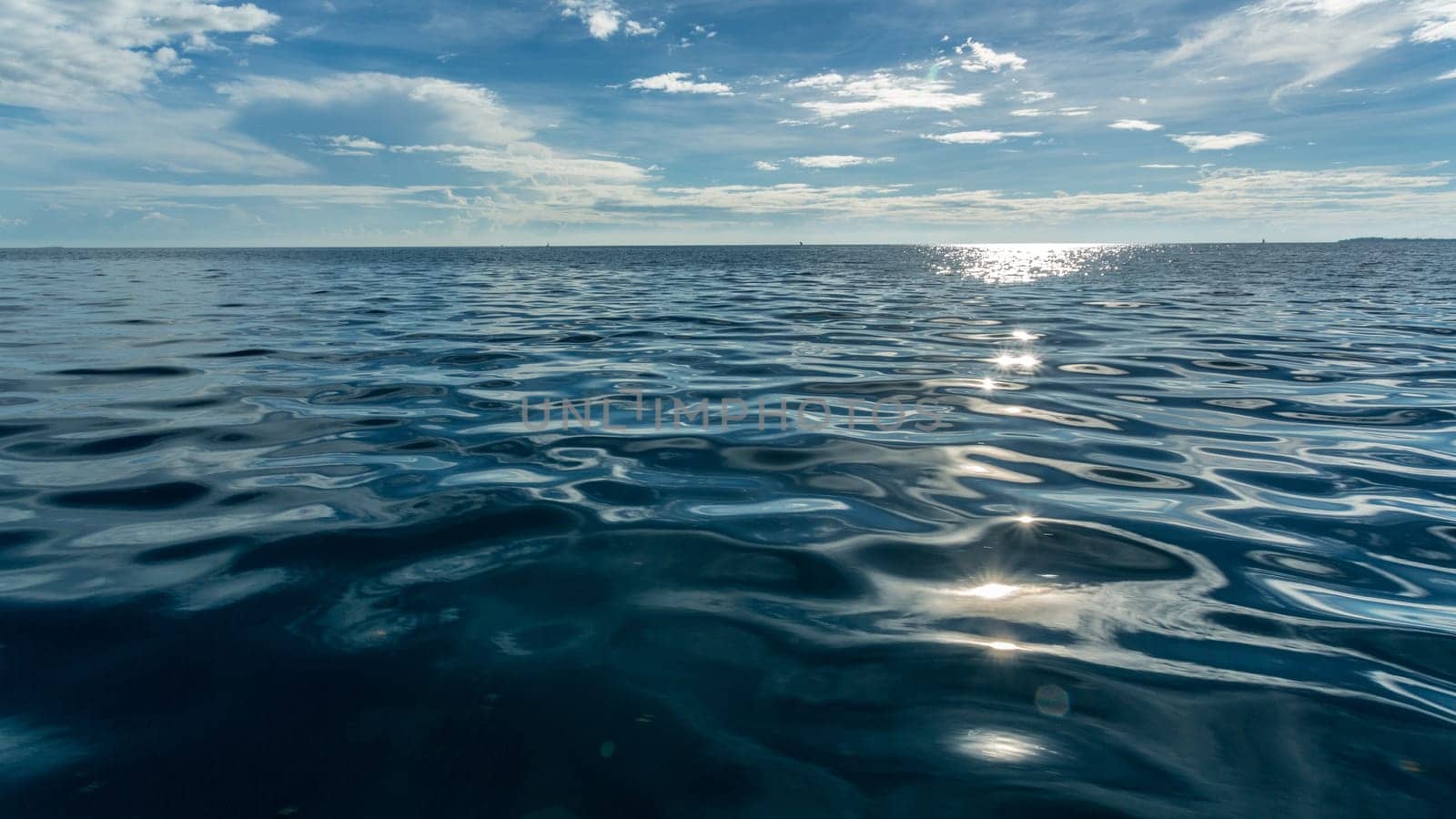 The late afternoon sun reflecting on the dark blue water of the Indian Ocean