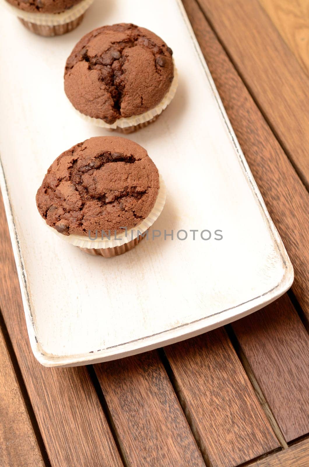 Sweet muffins on a white wooden bowl