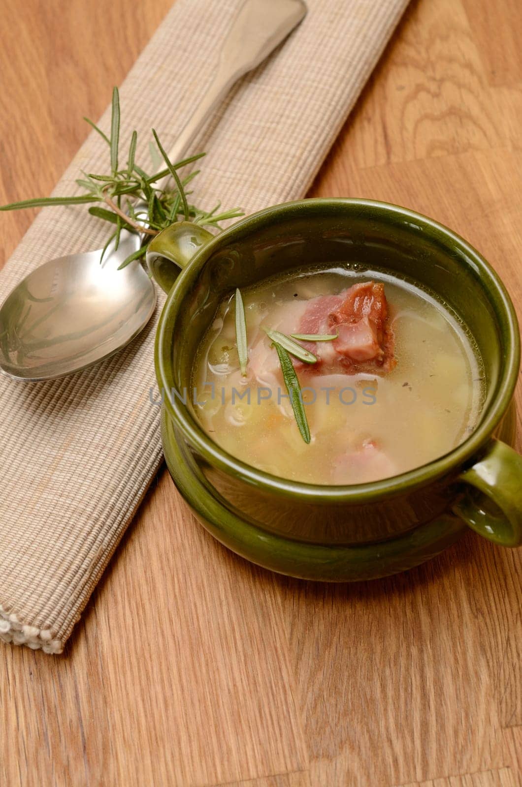 Green bowl with bean soup and bacon