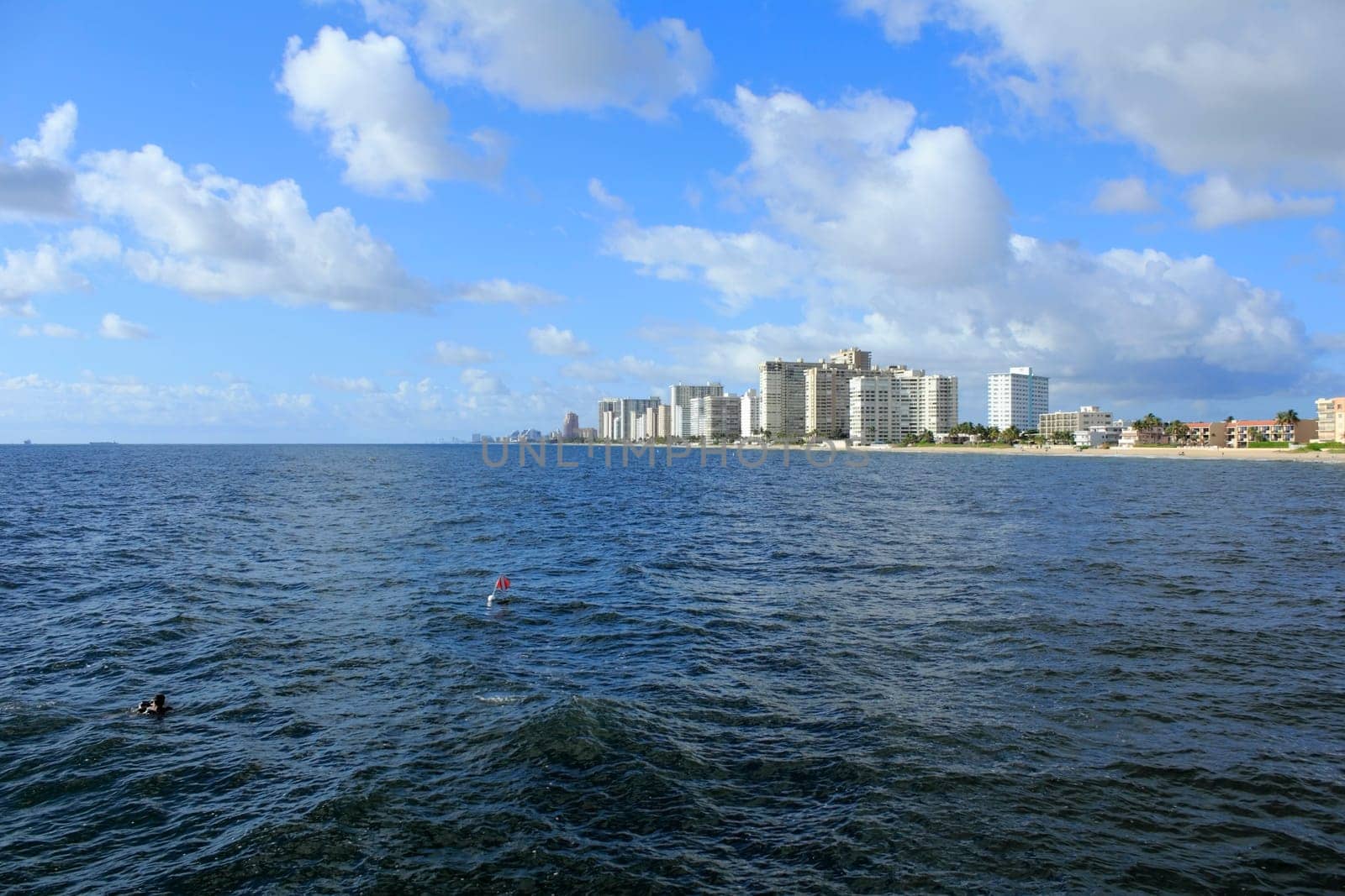 LAUDERDALE-BY-THE-SEA, FLORIDA - SEPTEMBER 21, 2013: Diver in the Atlantic Ocean and red and white diving spot flag where this diver and others were cleaning debris from the coral reef below the water