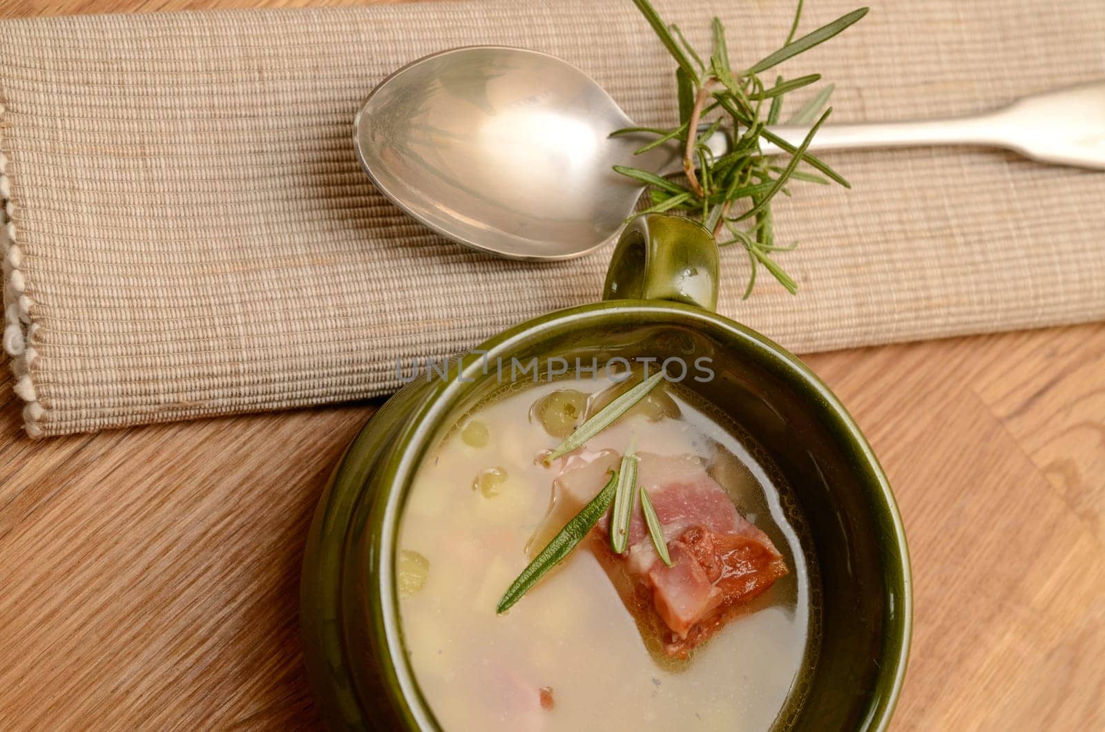 Green bowl with bean soup and bacon