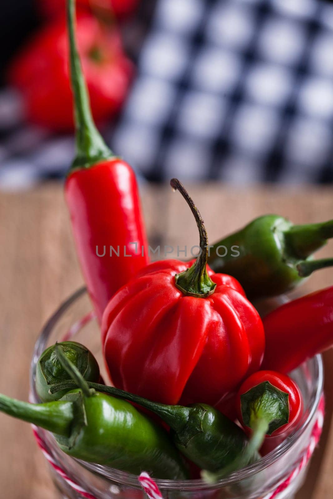 Closeup of red and green chili peppers in glass with decorative string
