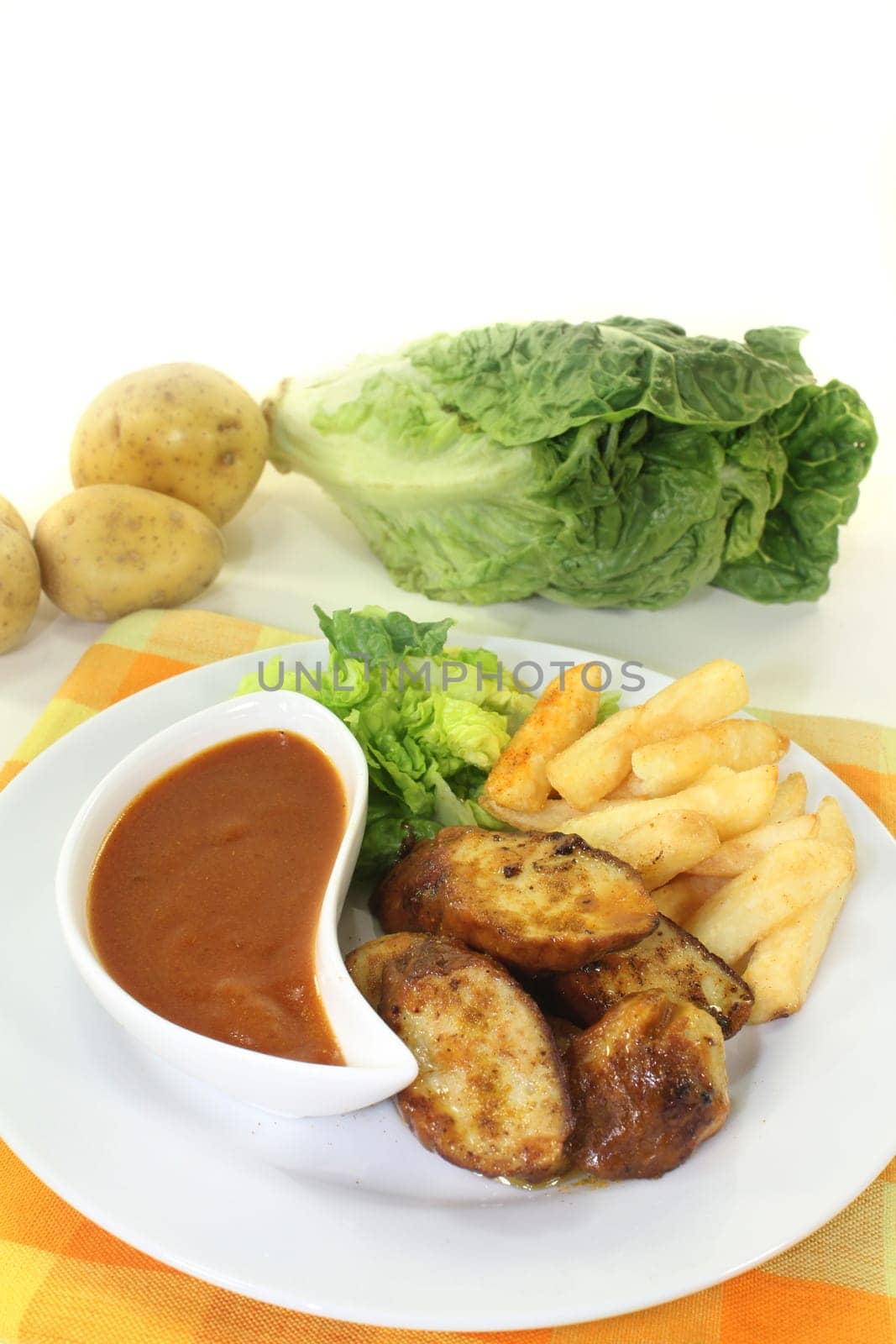 a currywurst with fries and salad
