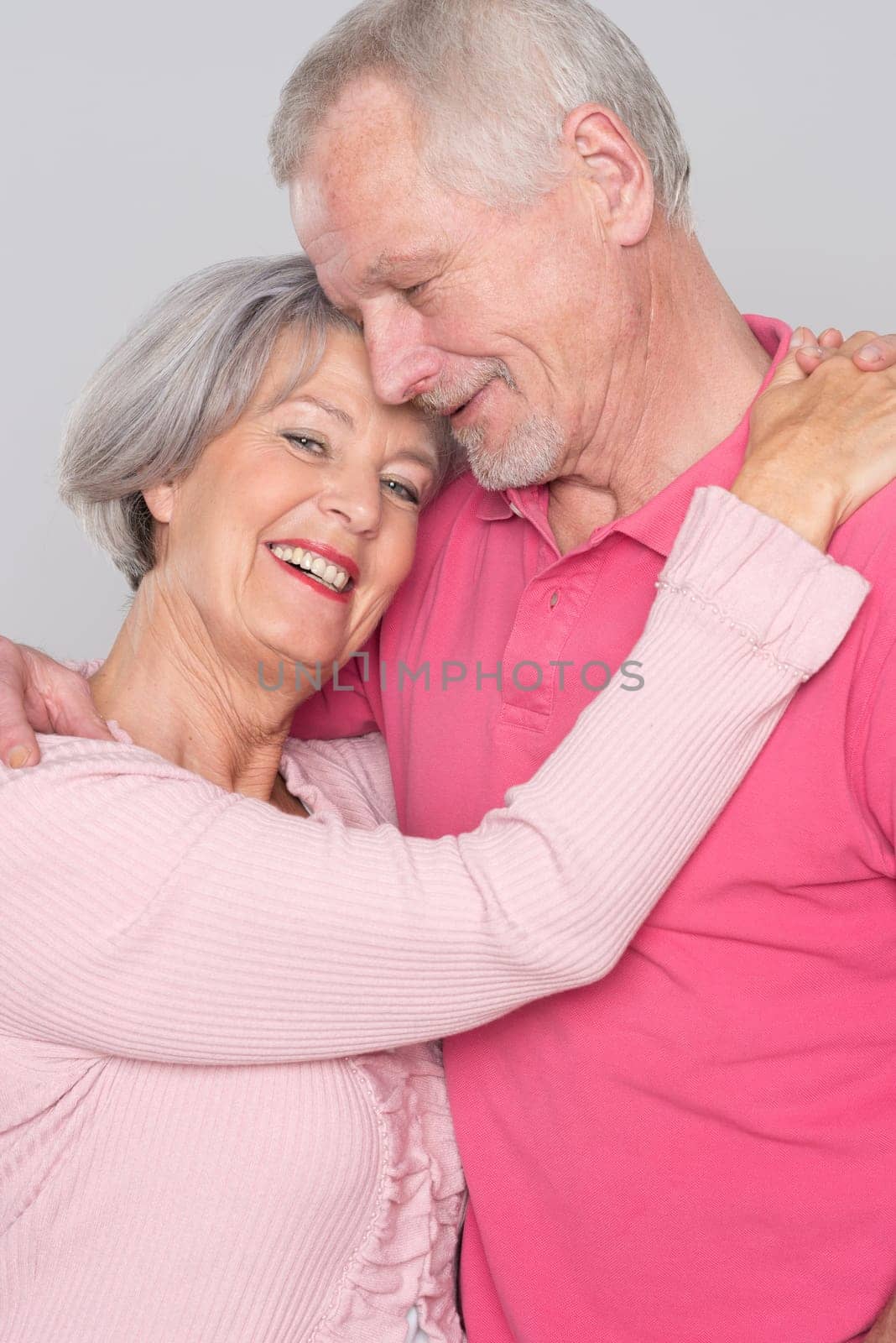 Happy senior couple against a grey background