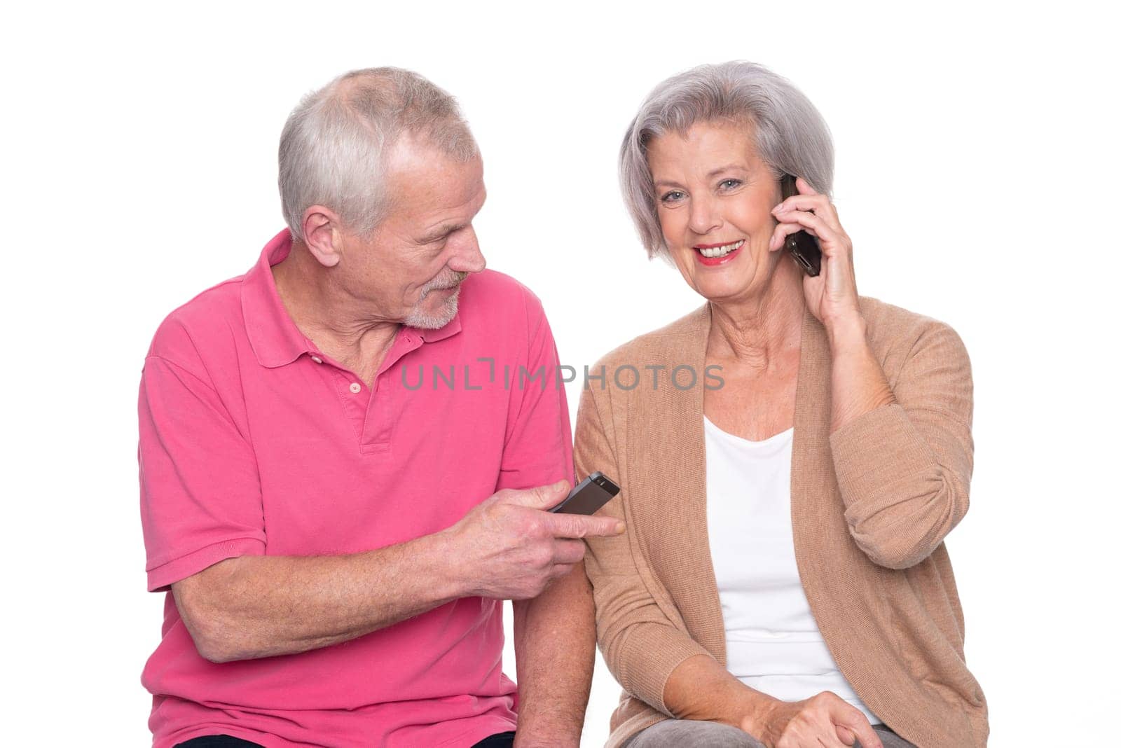 Senior couple with smartphone against a white background