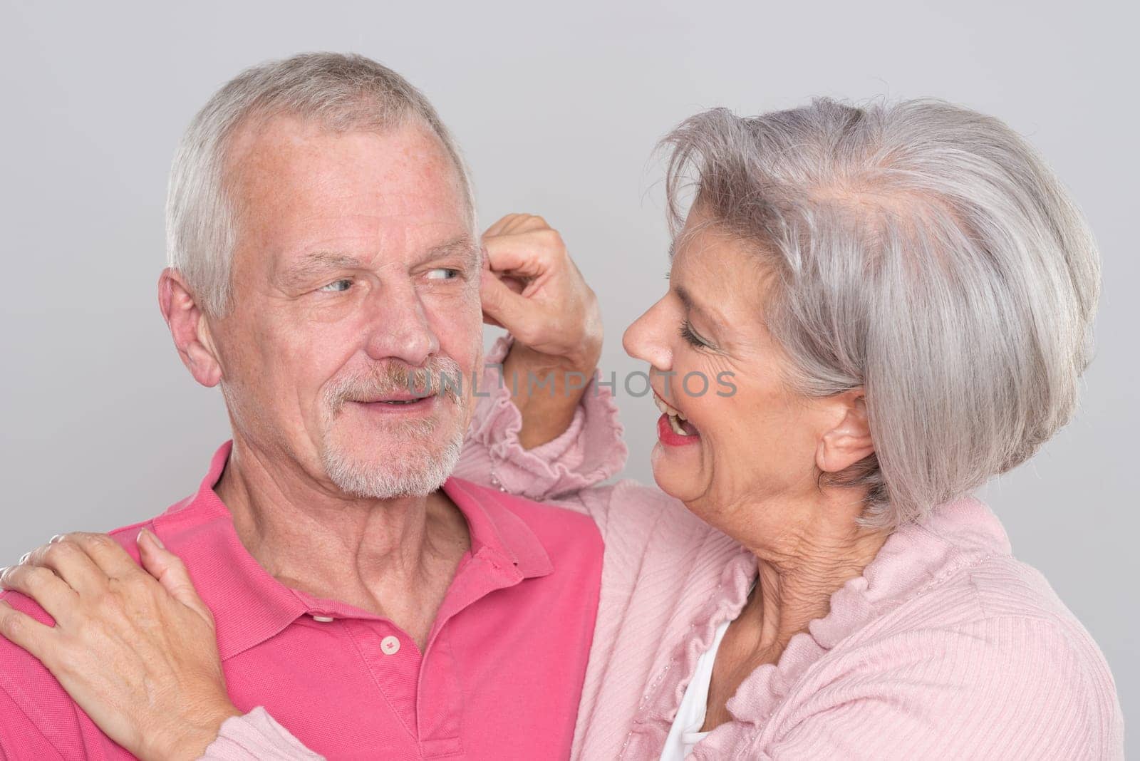 Happy senior couple against a grey background