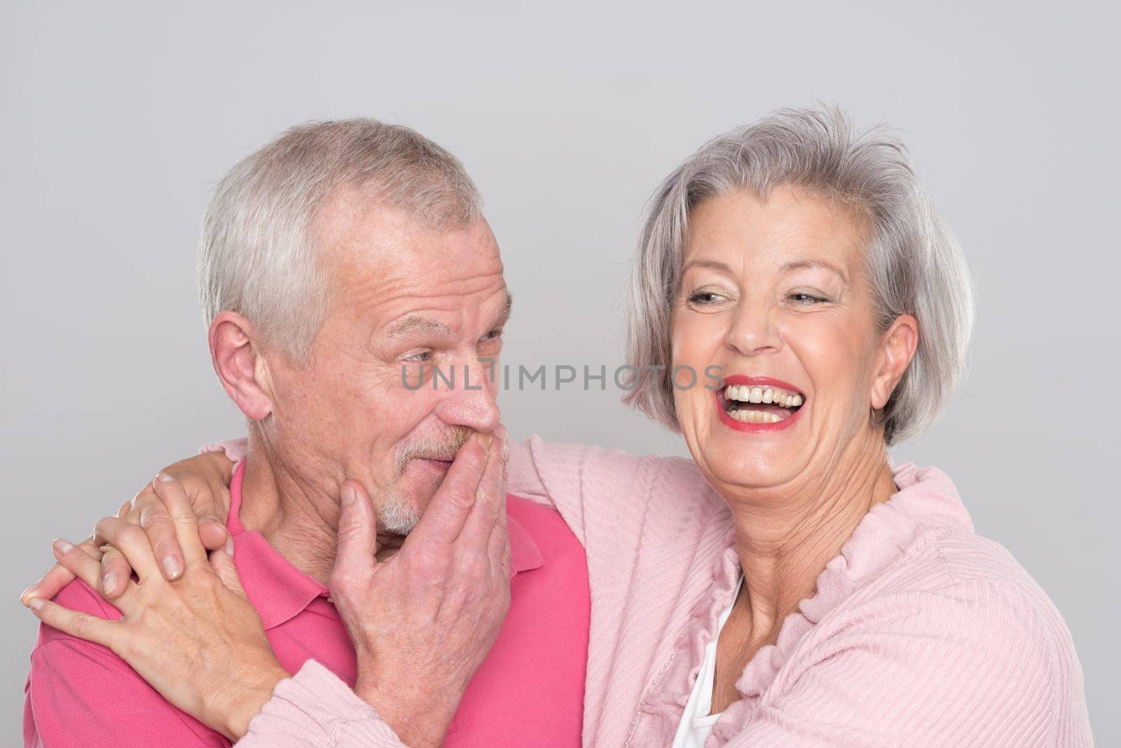 Happy senior couple against a grey background