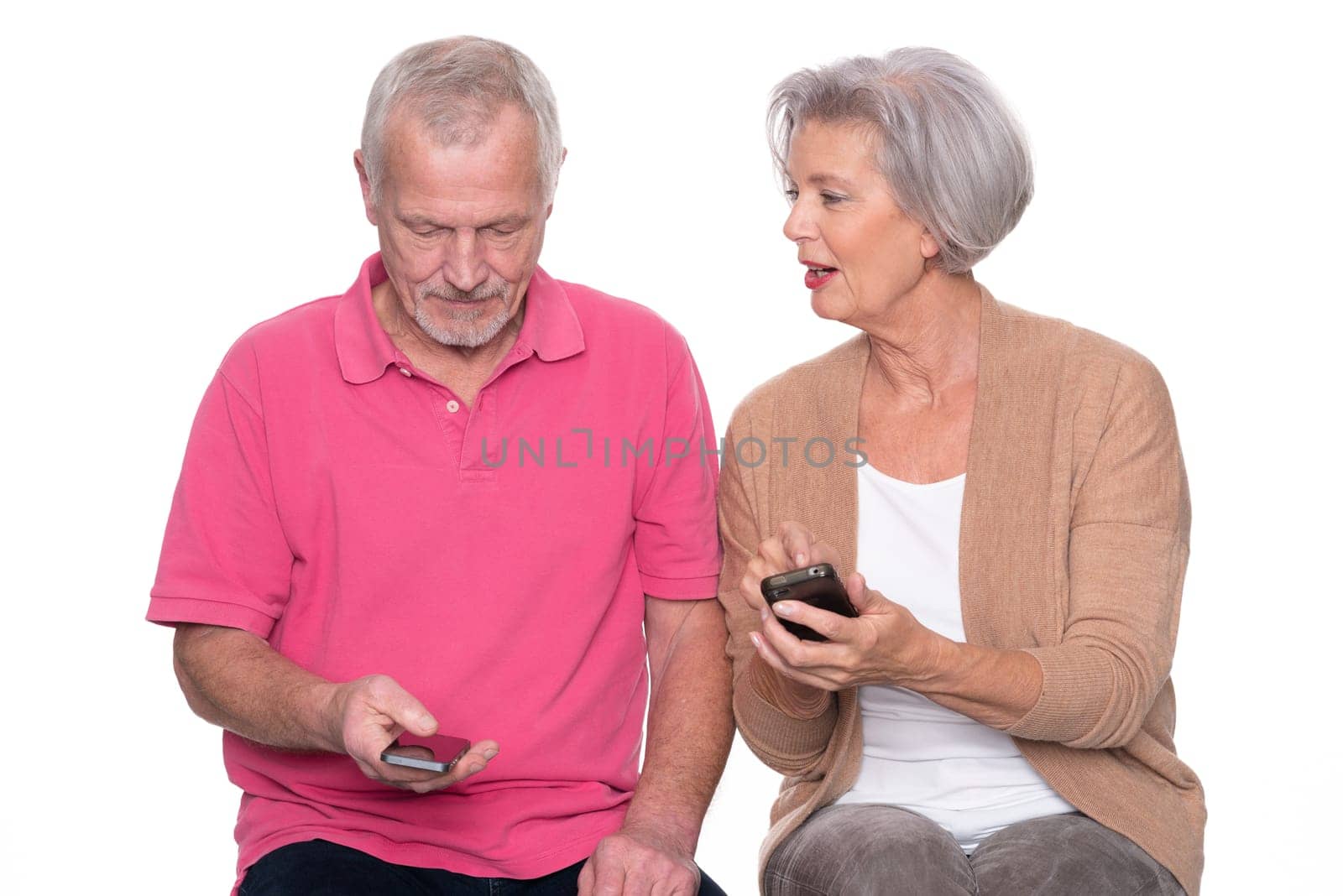 Senior couple with smartphone against a white background