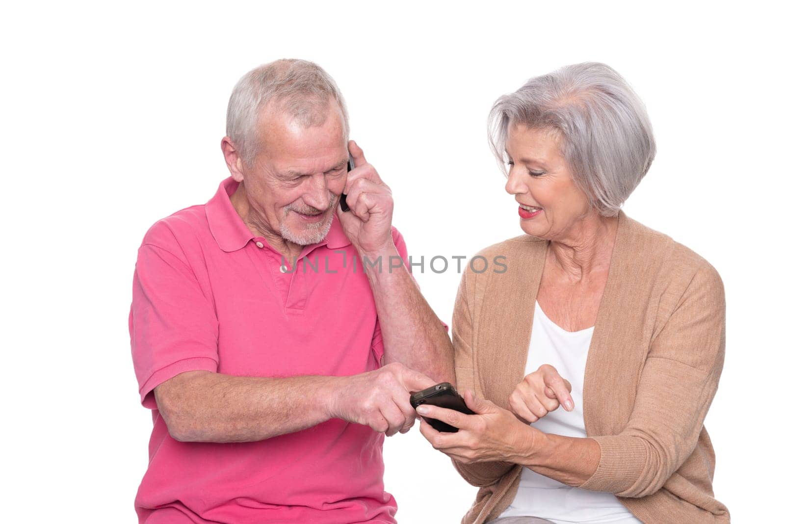 Senior couple with smartphone against a white background