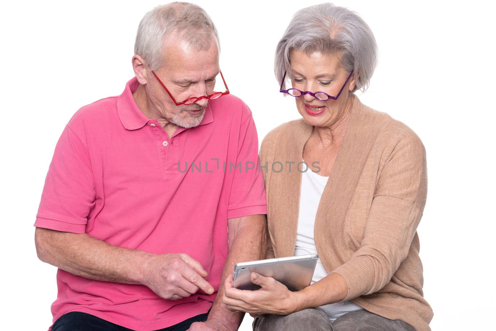 Senior couple with tablet against a white background