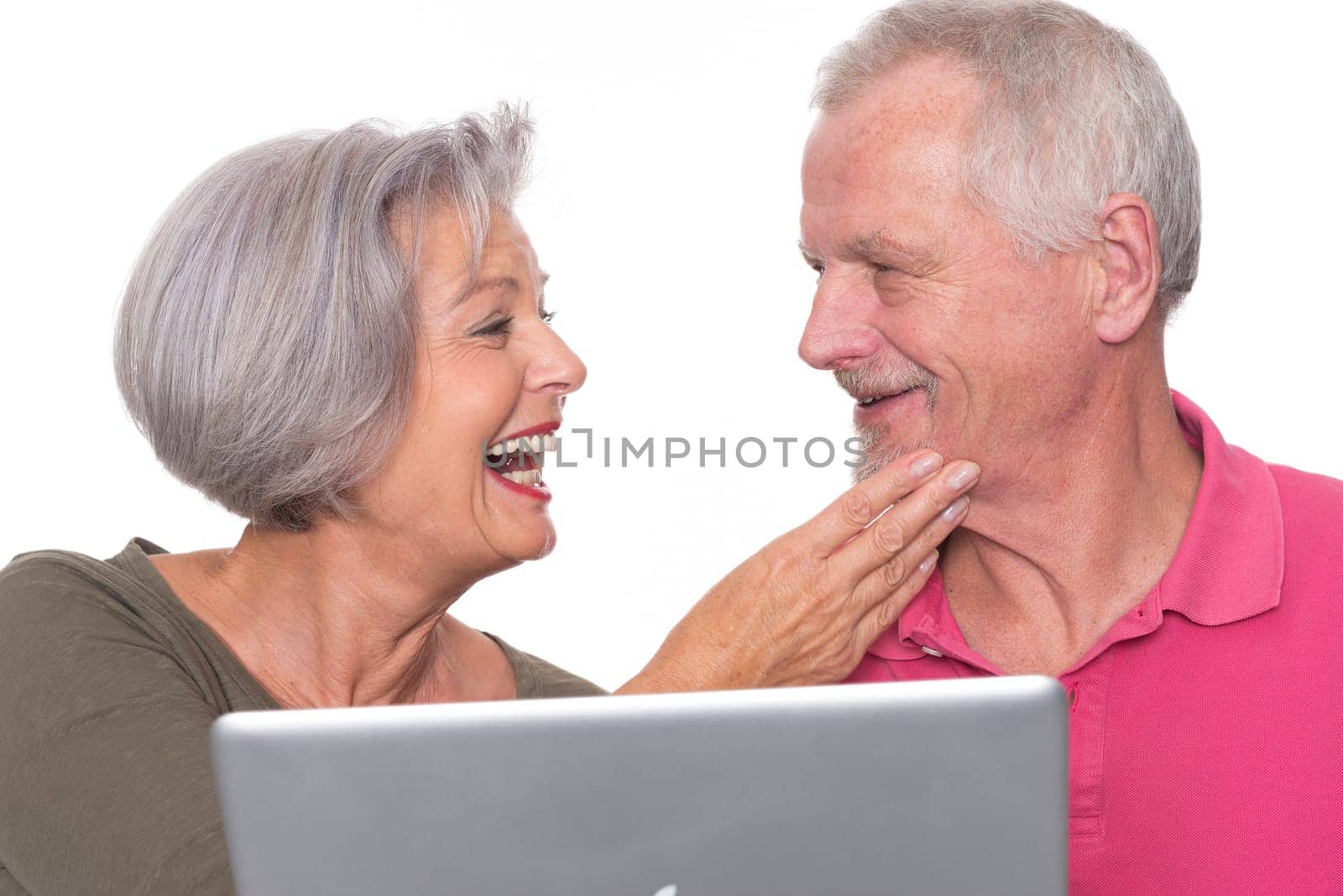 Senior couple with computer against a white background