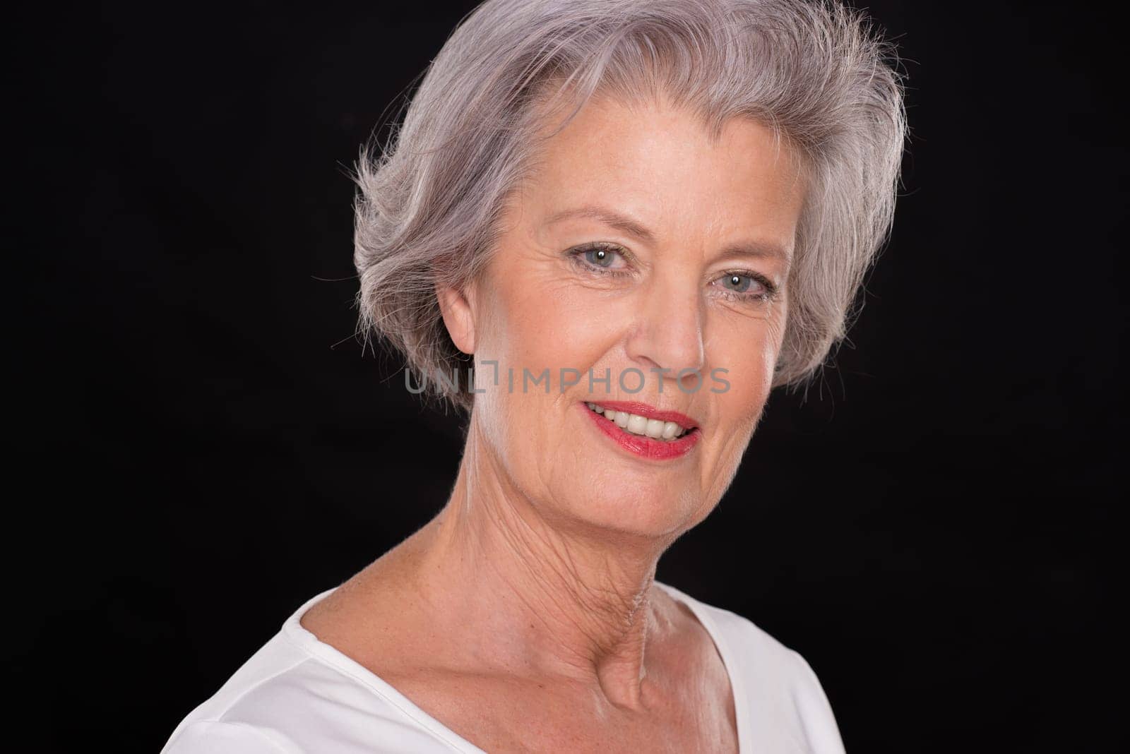 Portrait of a senior woman against a black background
