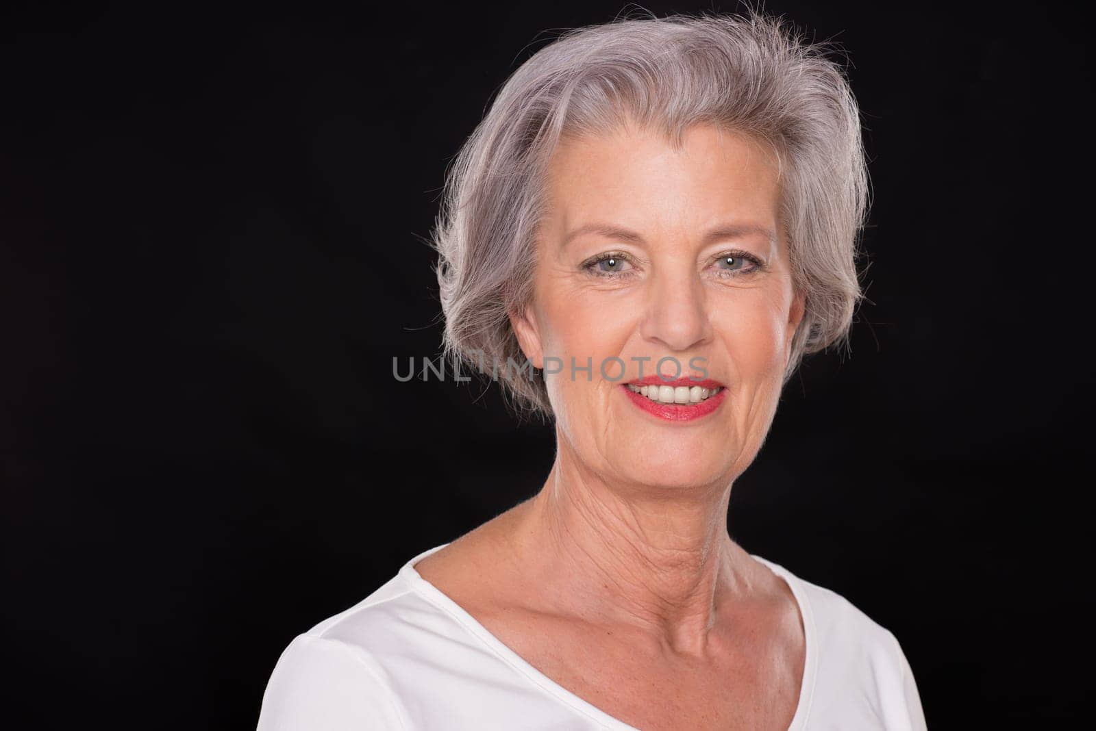 Portrait of a senior woman against a black background