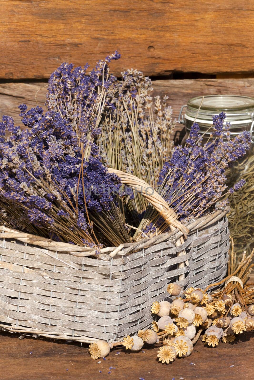 Basket with lavender and poppy pods in front