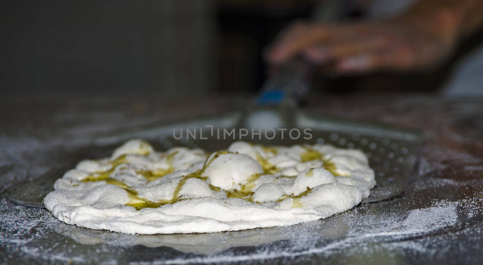 Handling, working and cooking pizza dough with shovel