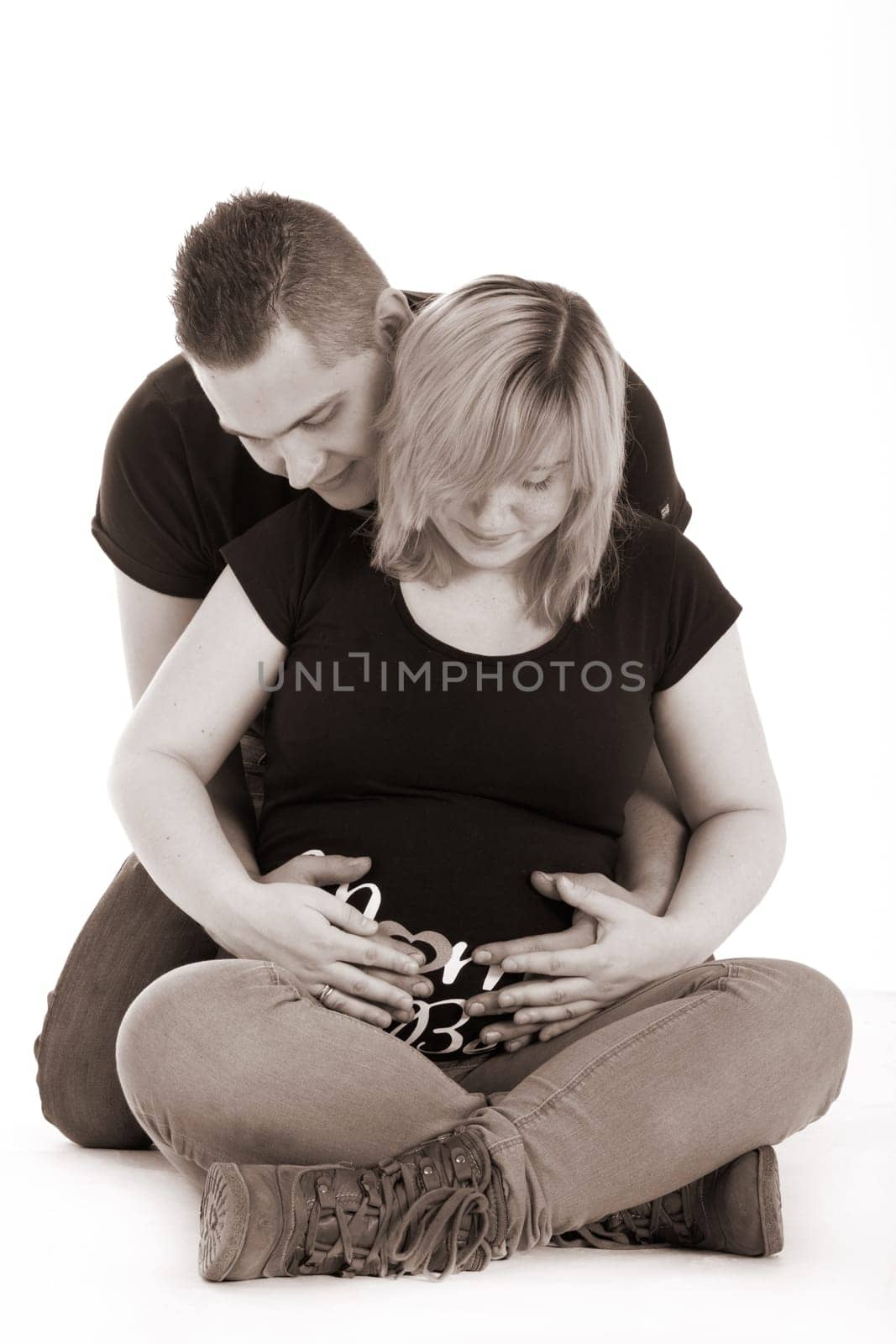 Happy young pregnant couple in the studio