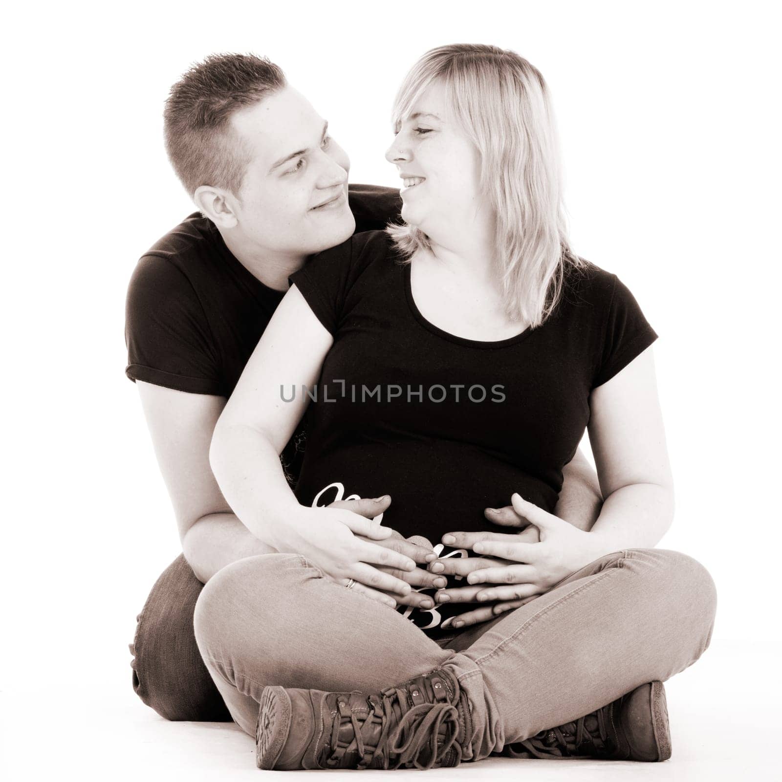 Happy young pregnant couple in the studio