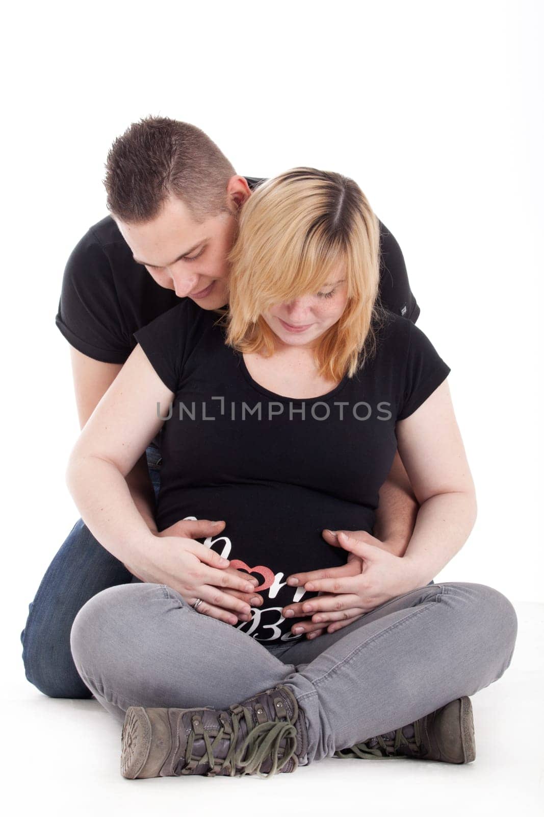 Happy young pregnant couple in the studio