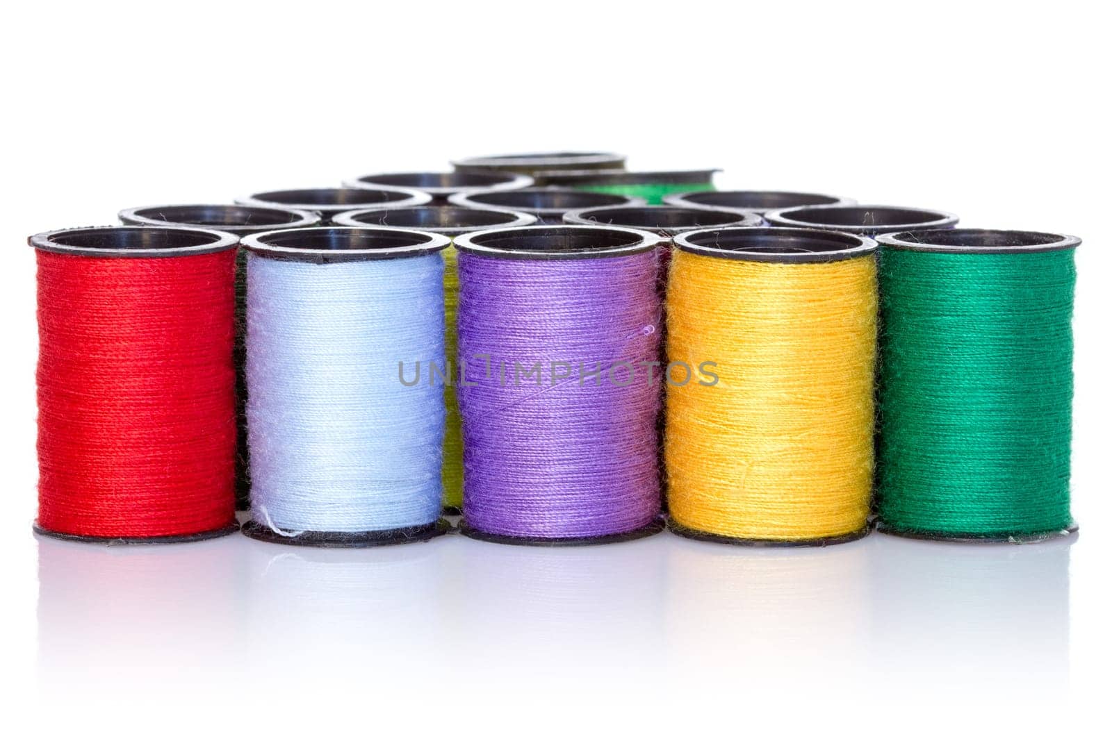 Colorful bobbins with reflection on white background