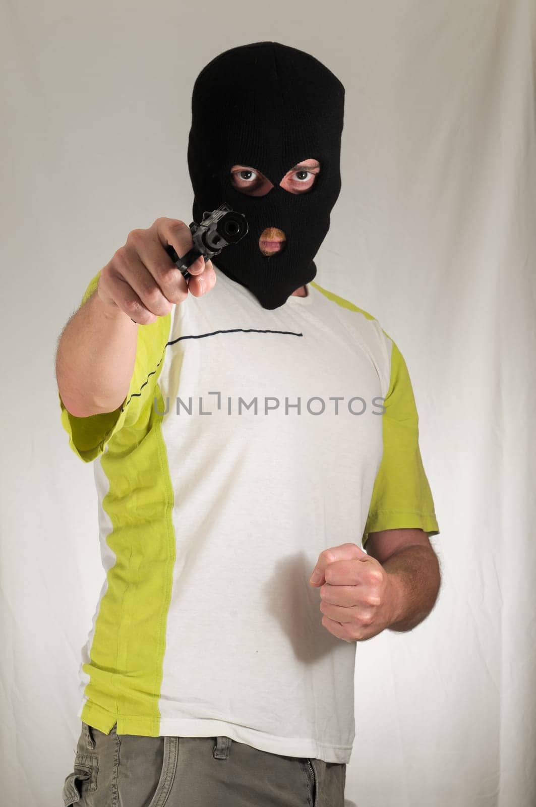 White Dressed Young Man Holding a Pistol Gun