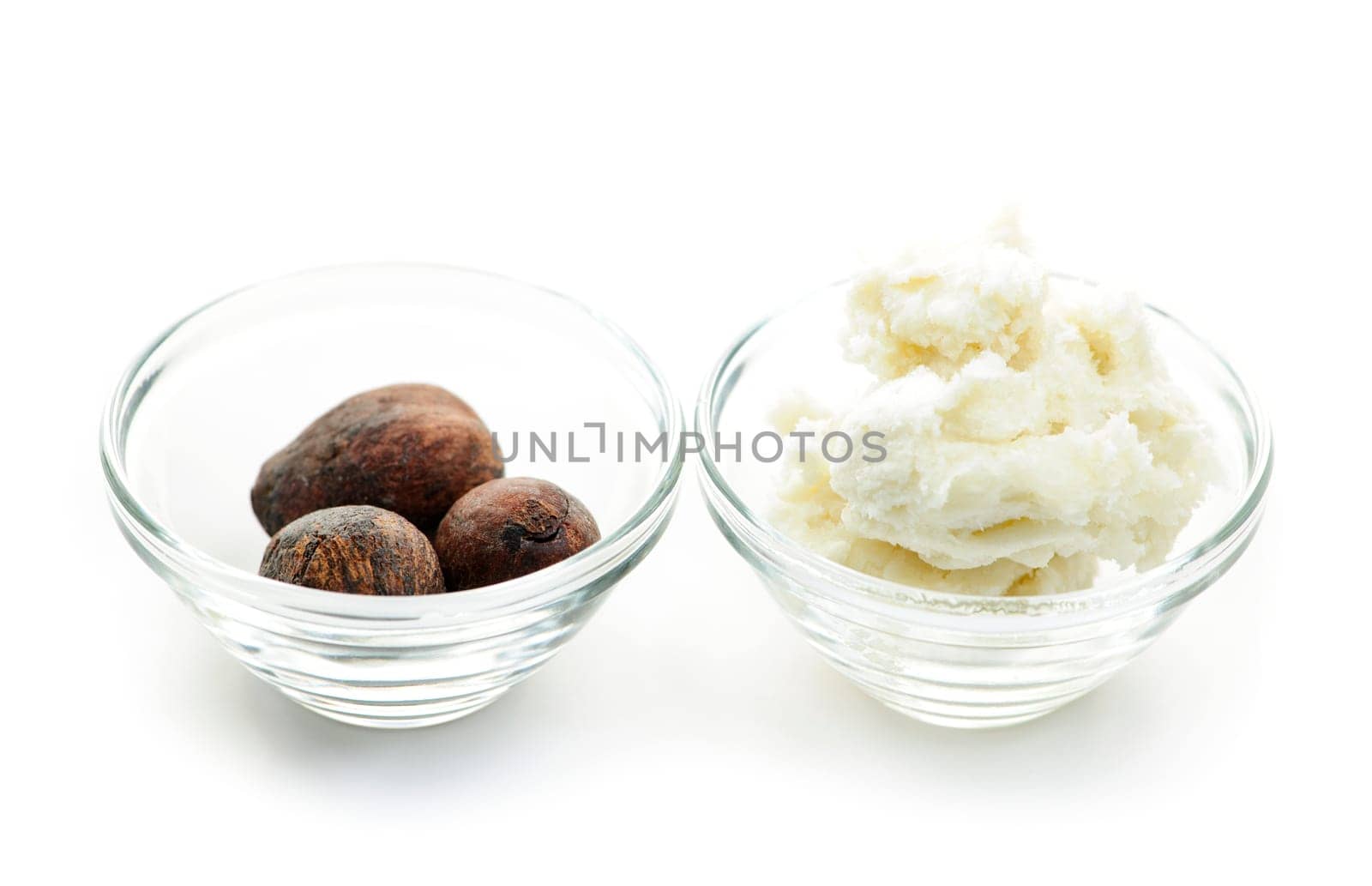 Shea butter and nuts in glass bowls isolated on white