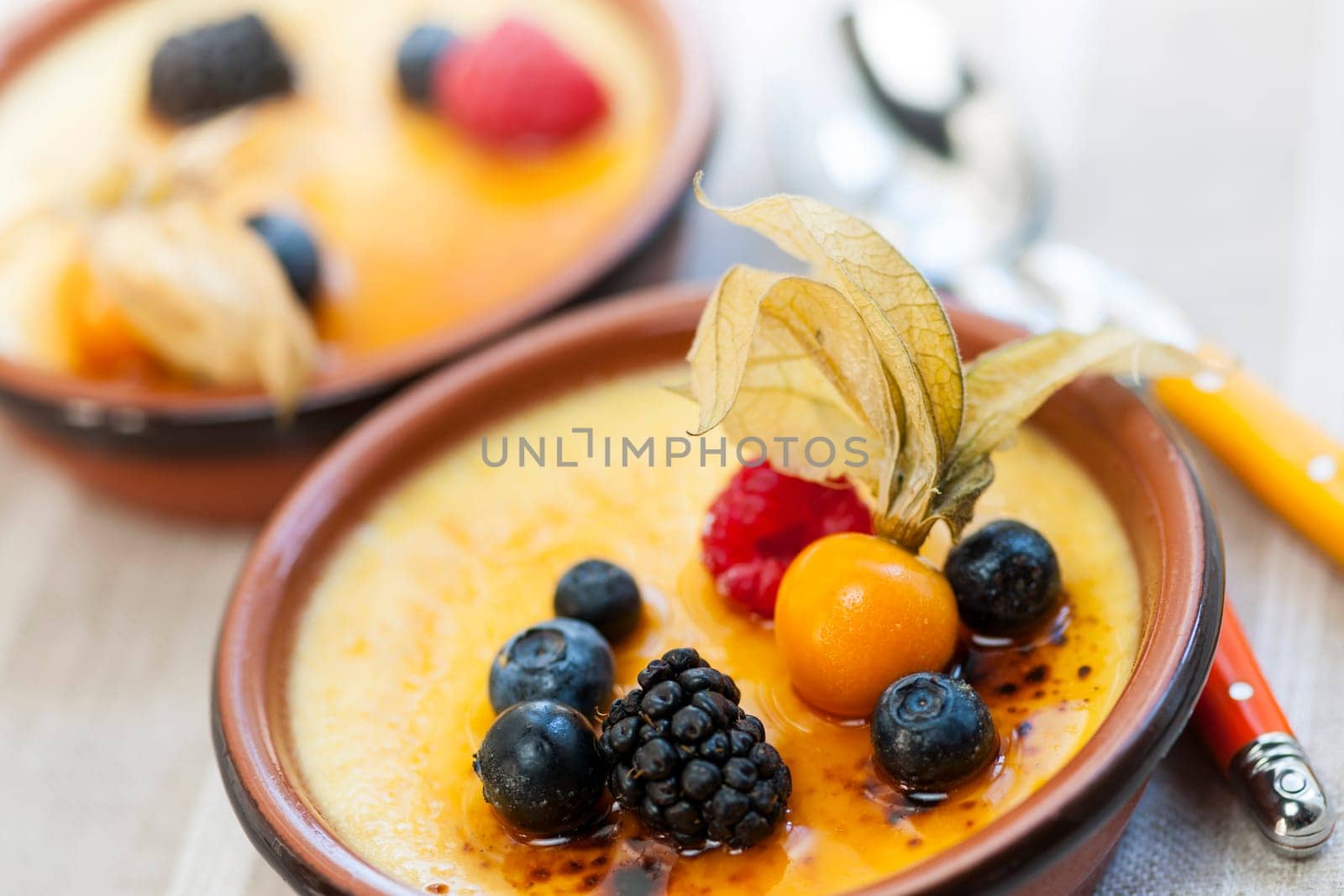 Sweet creme brulee desserts topped with fresh berries