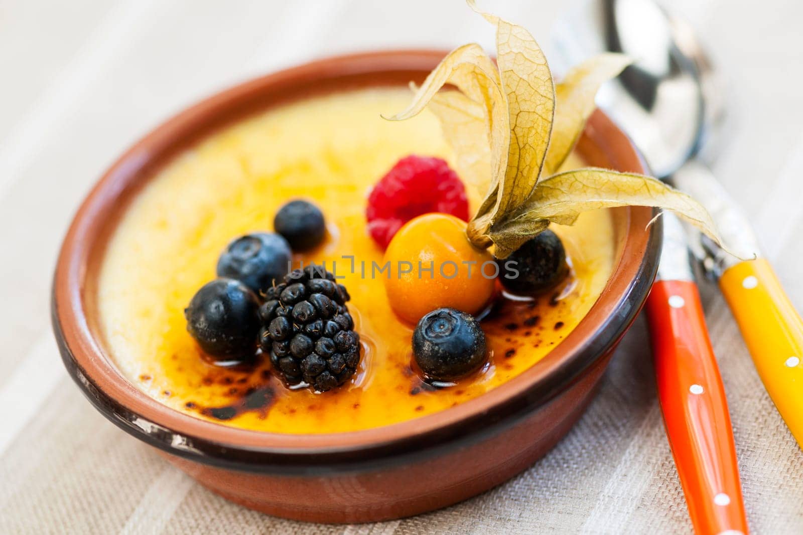 Sweet creme brulee desserts topped with fresh berries