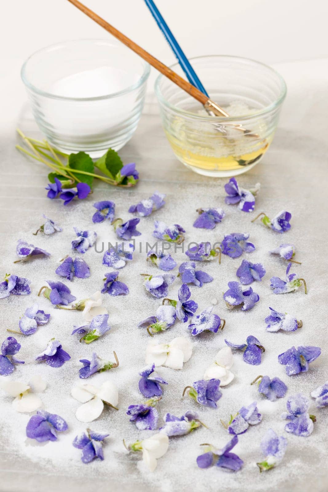 Making candied violet flowers with egg whites and sugar