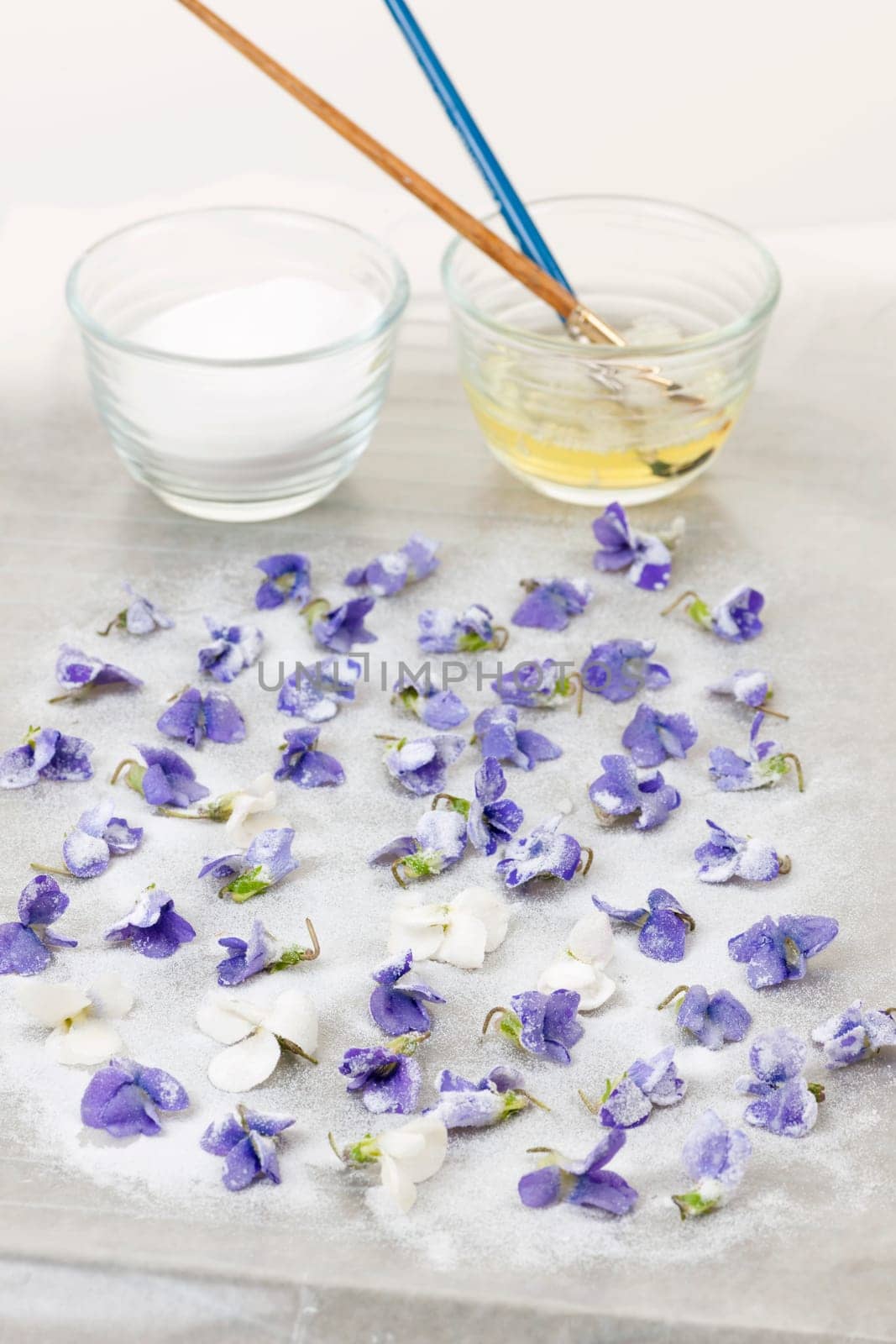 Making candied violet flowers with egg whites and sugar