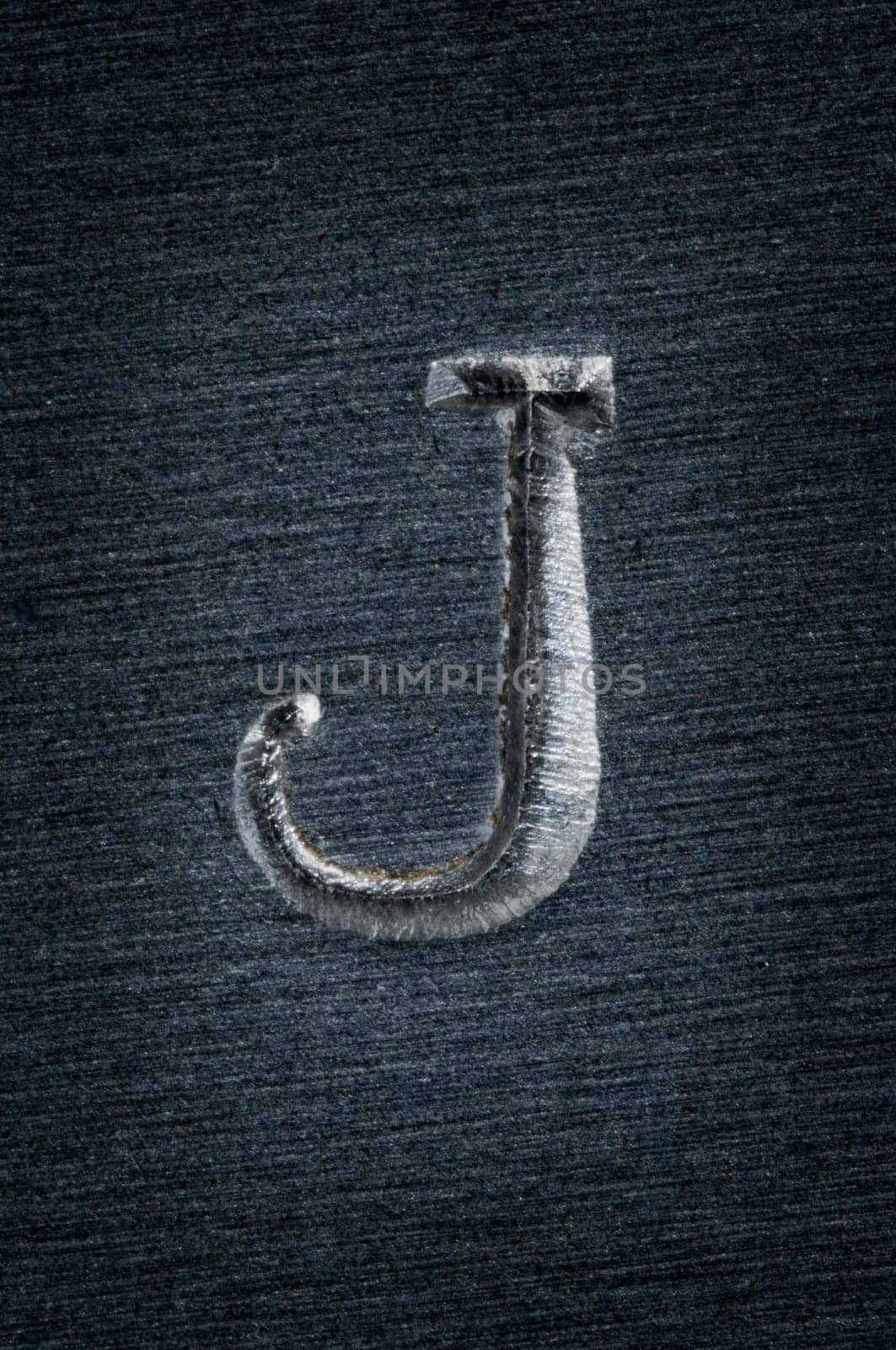 Macro image of the letter "J"" in metal"