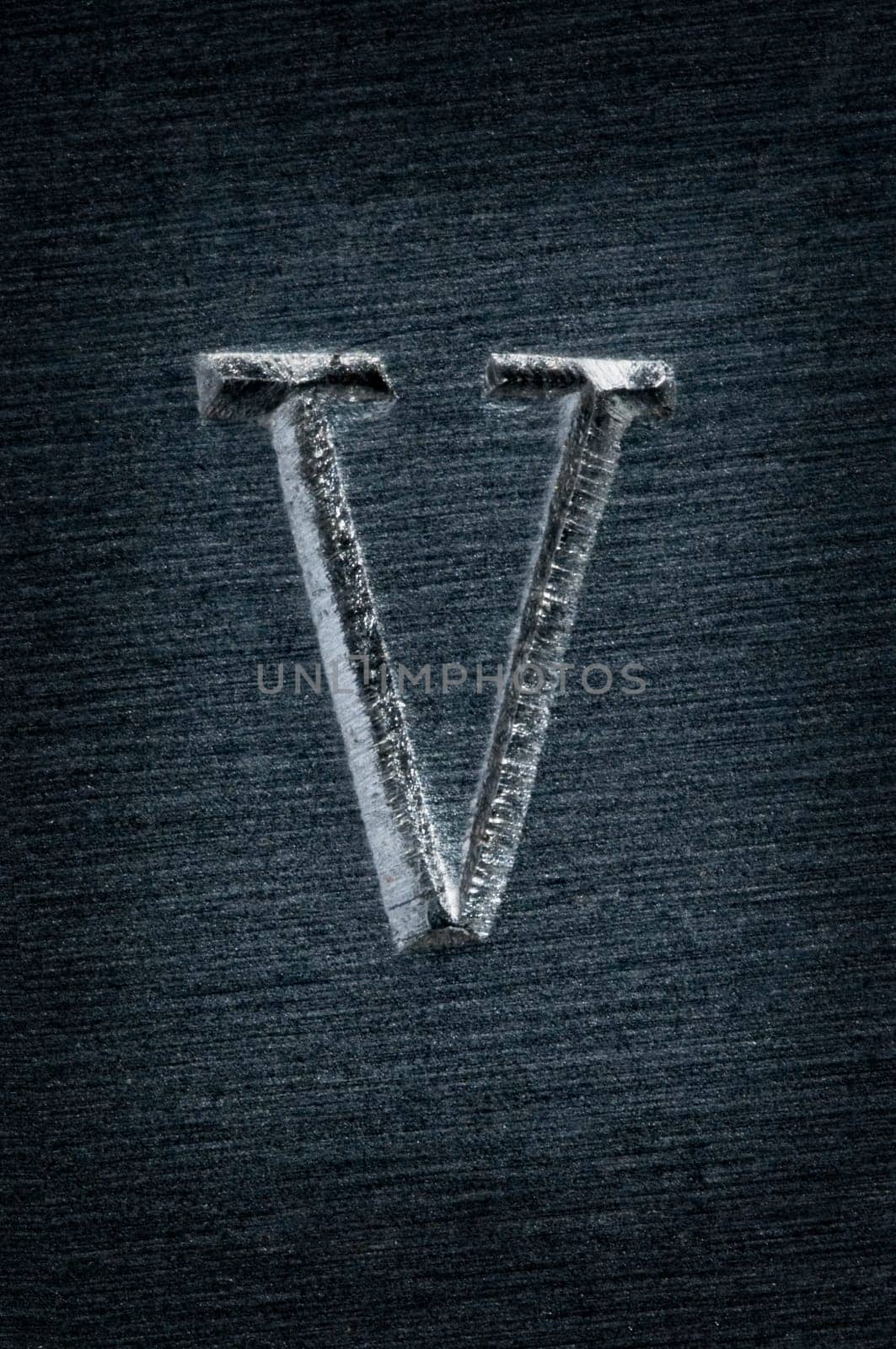 Macro image of the letter "V"" in metal"