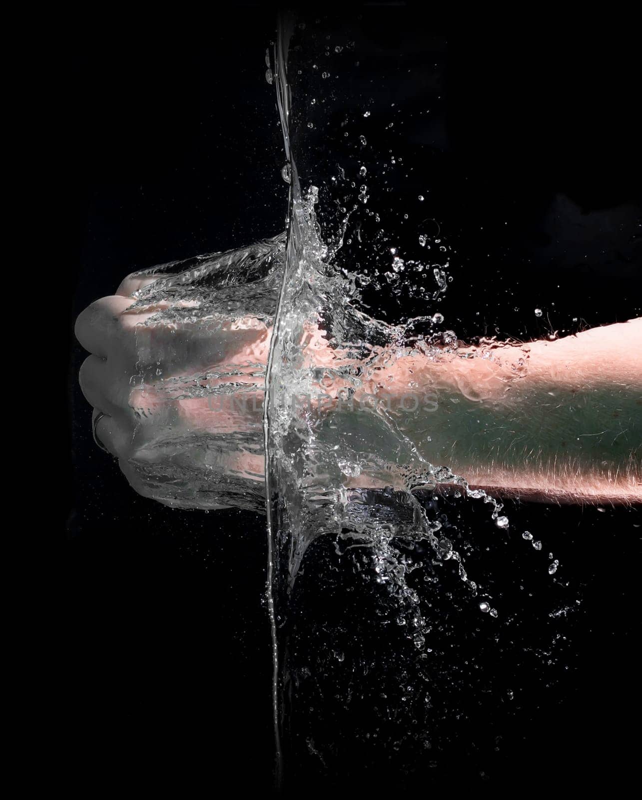 Fist punch into water with big splashes, on a black background