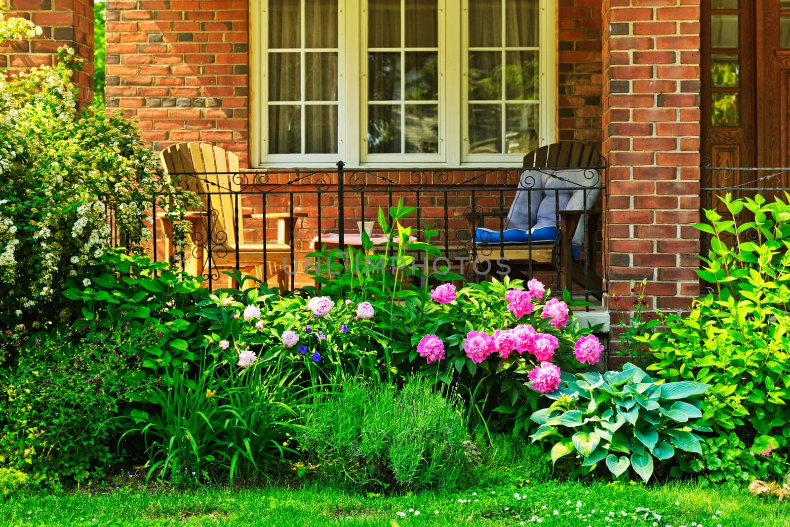 Front of home with chairs and flower garden