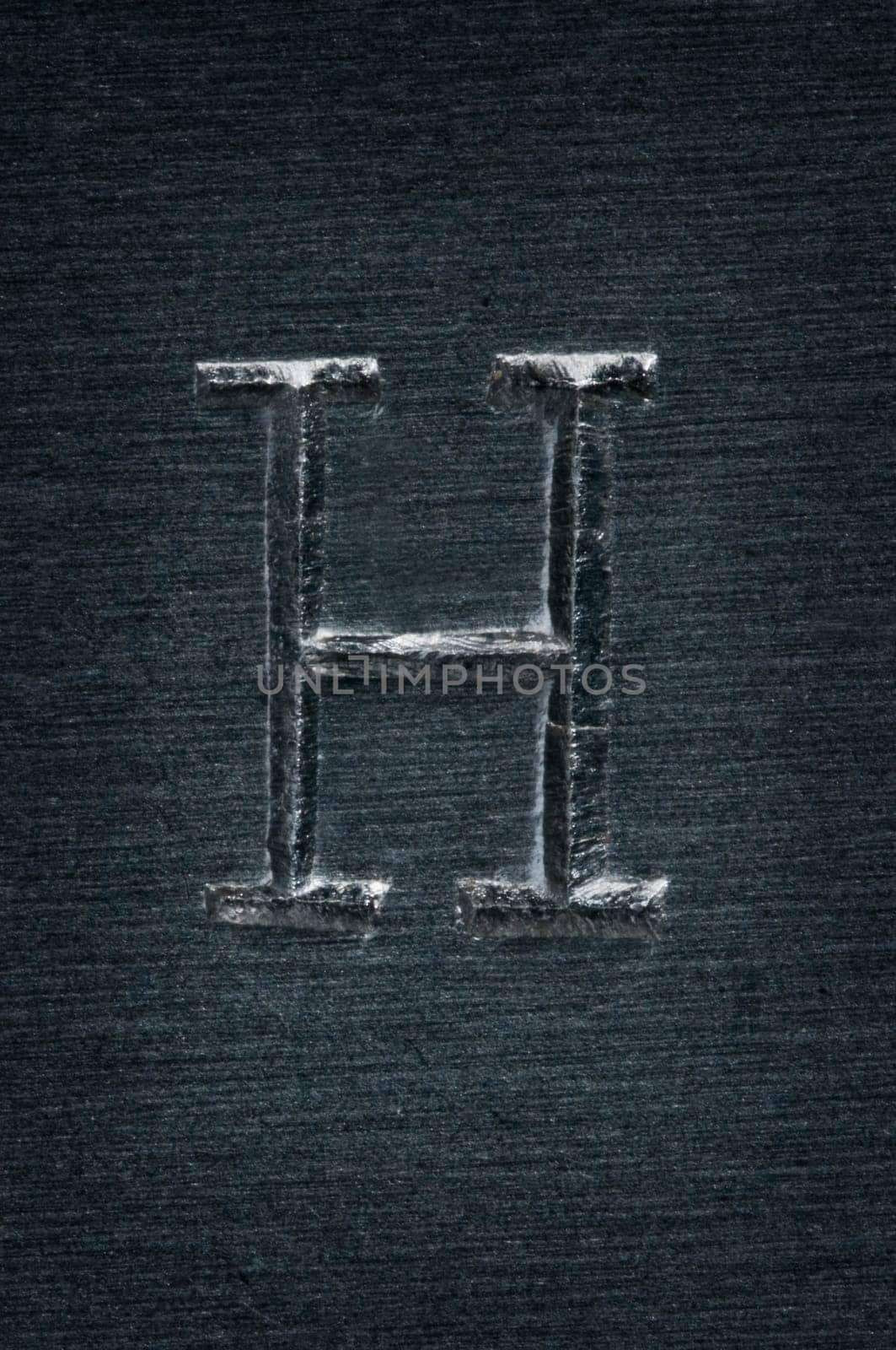 Macro image of the letter "H"" in metal"