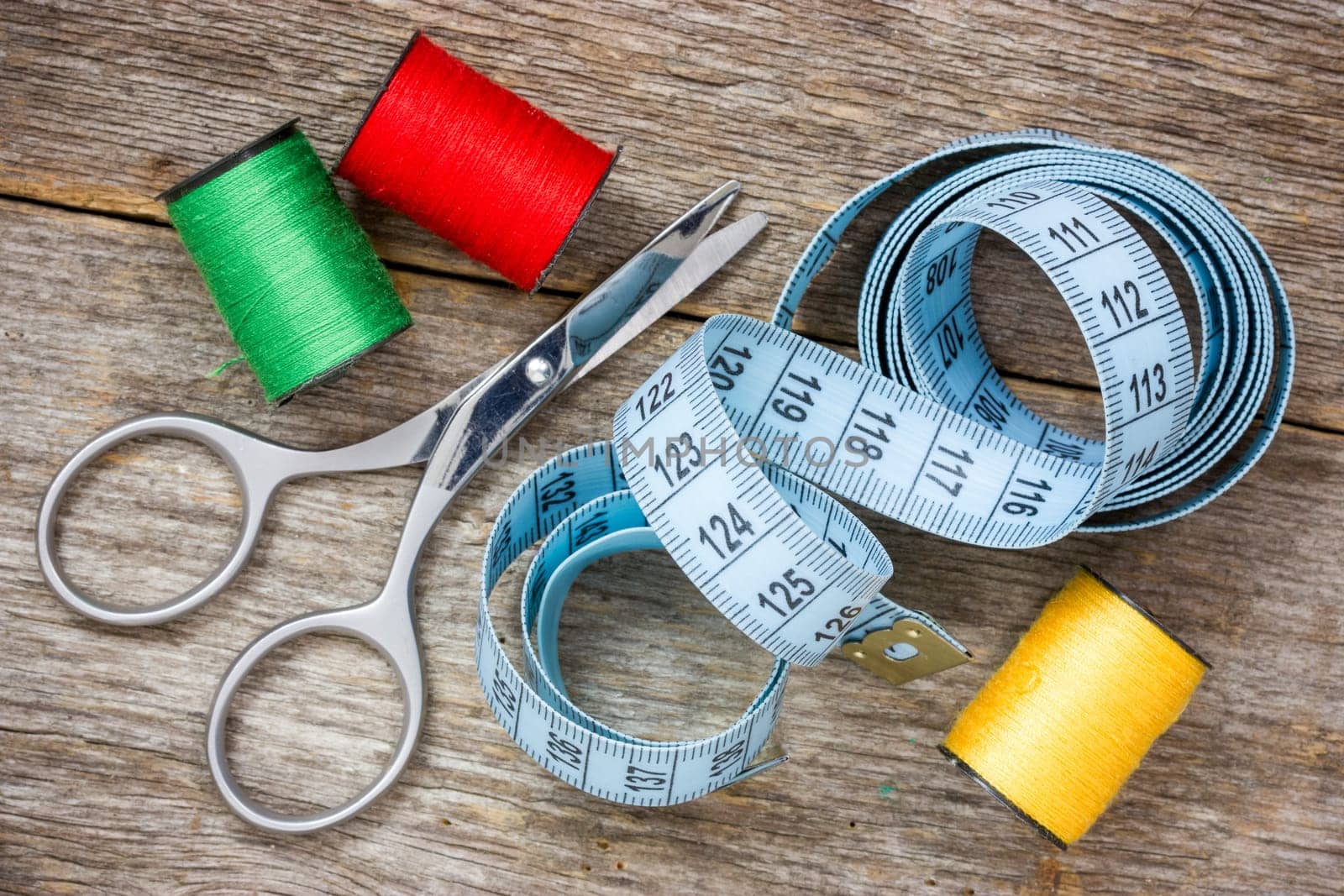 Tools for sewing on the wooden background