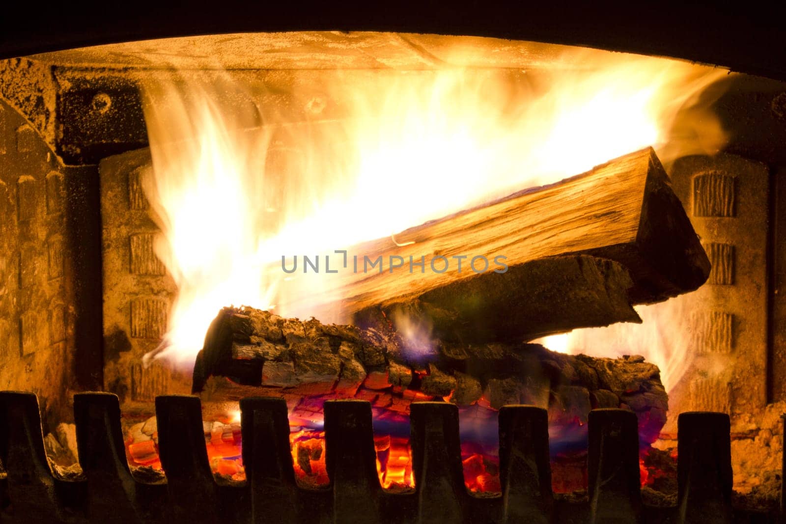 Fire place detail of a fire burning inside.