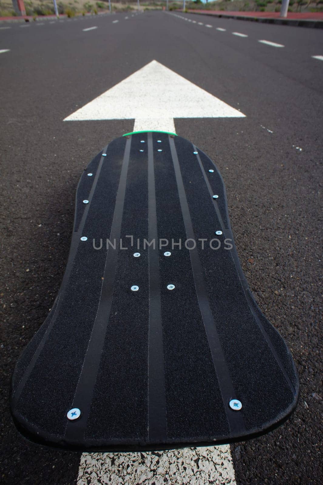 Vintage Style Longboard Black Skateboard on an Empty Asphalt Desert Road