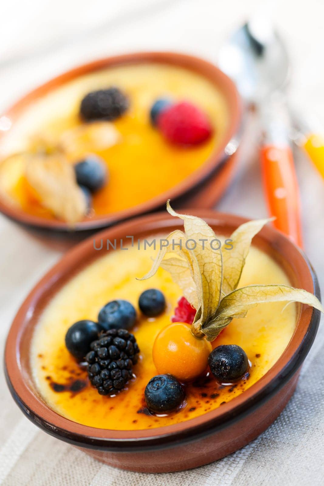 Sweet creme brulee desserts topped with fresh berries