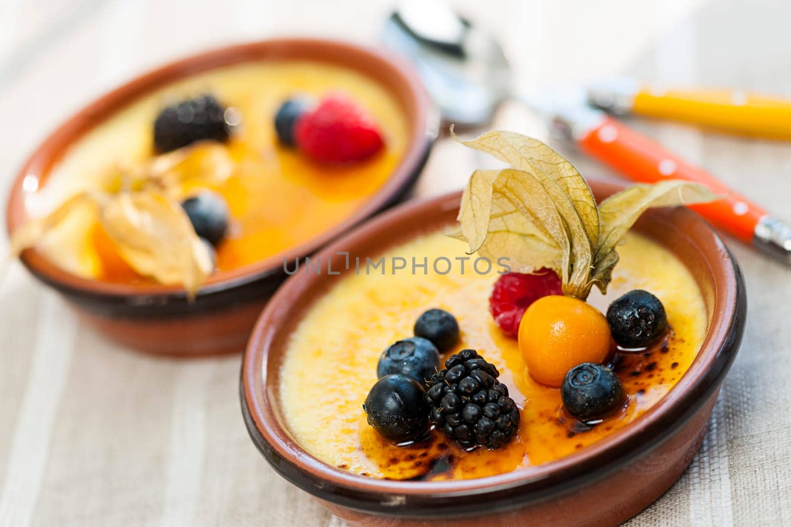 Sweet creme brulee desserts topped with fresh berries