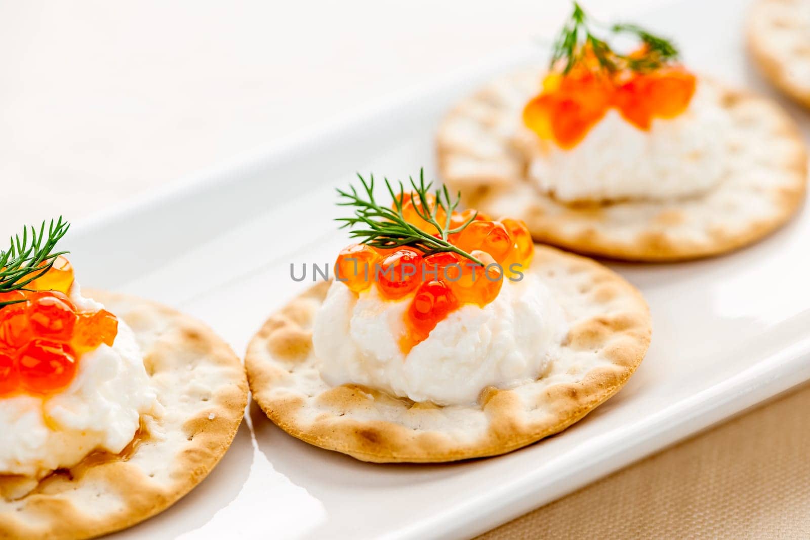 Closeup of caviar and cream cheese appetizer on crackers