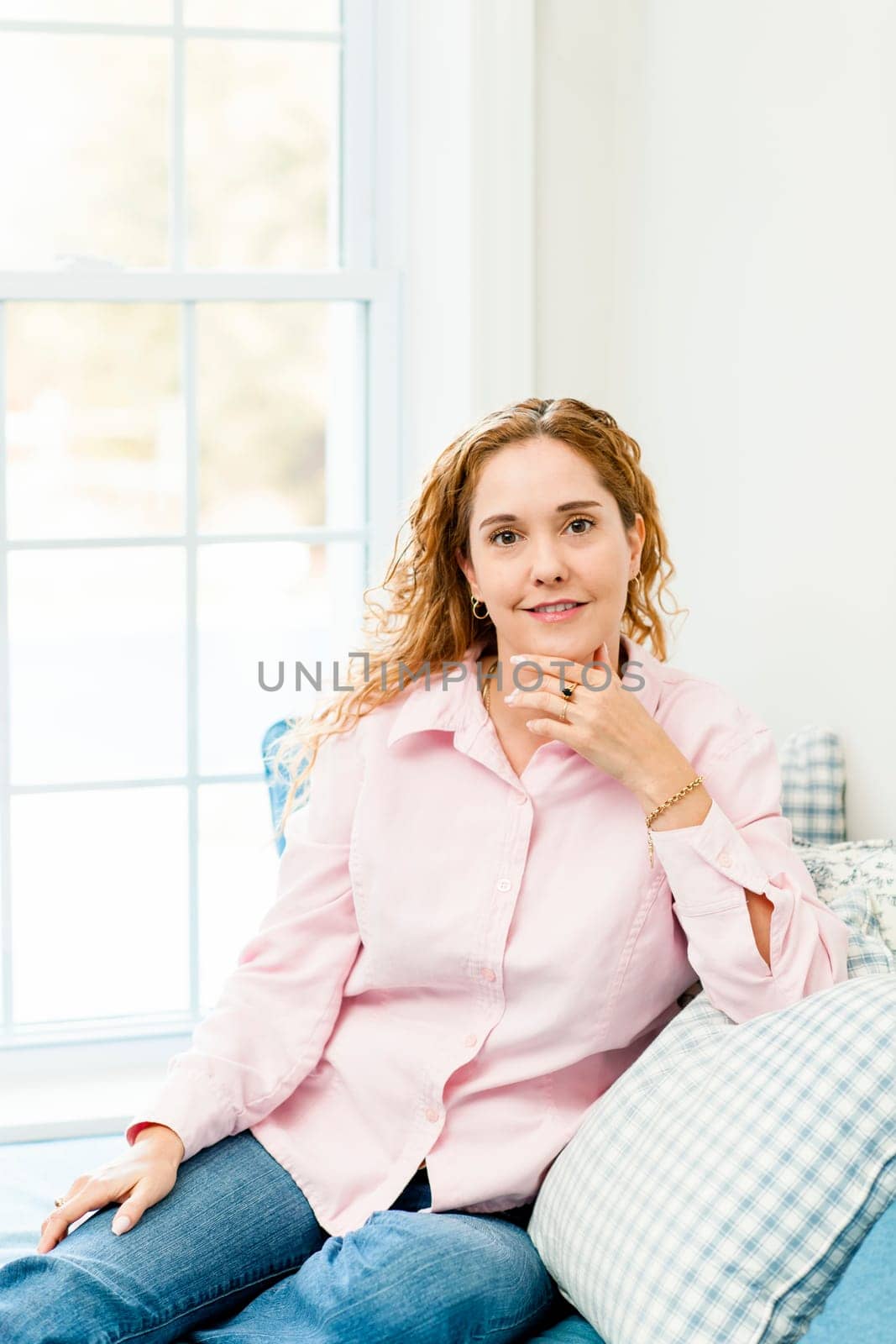 Smiling caucasian woman relaxing on couch by window