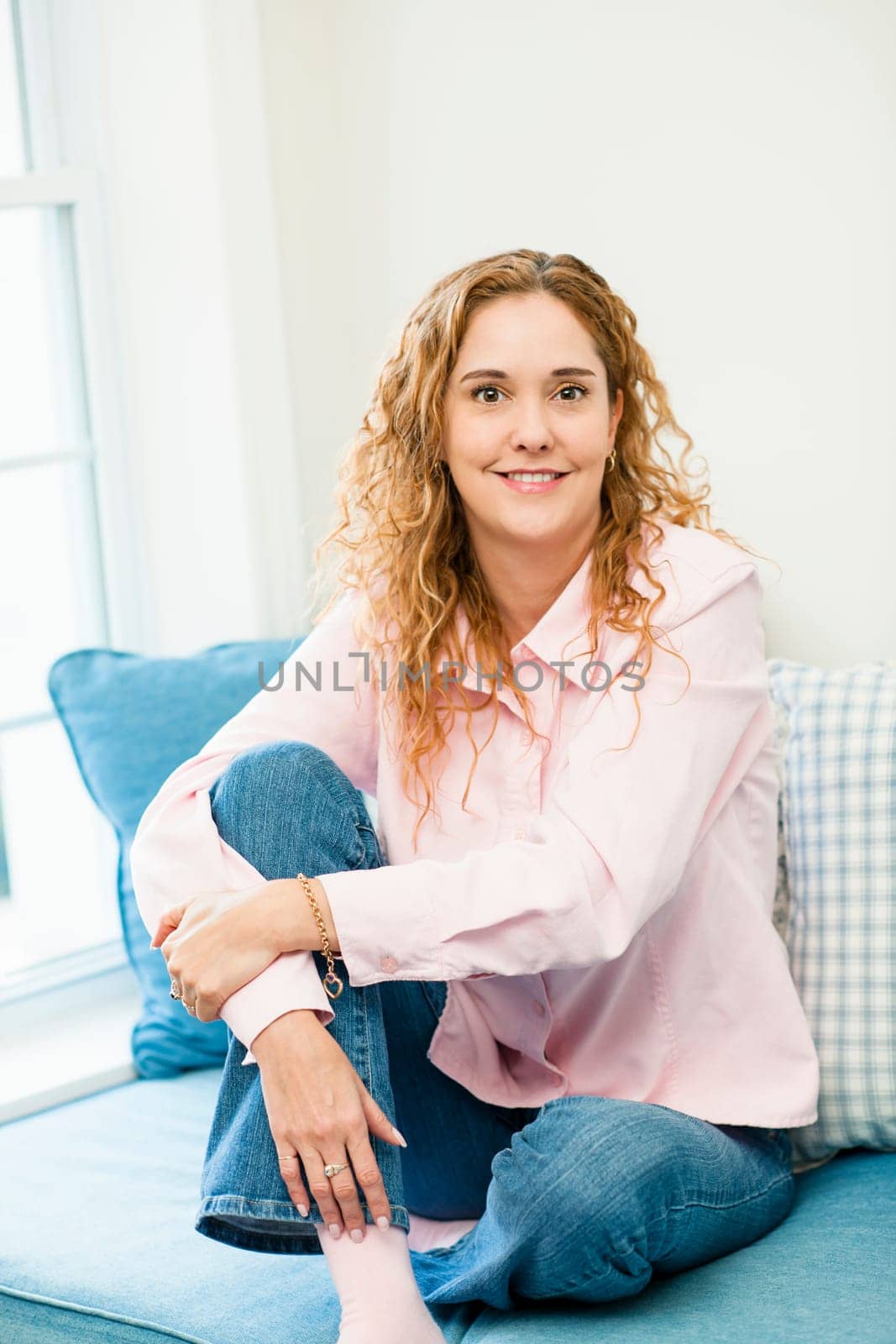 Smiling caucasian woman relaxing on couch by window