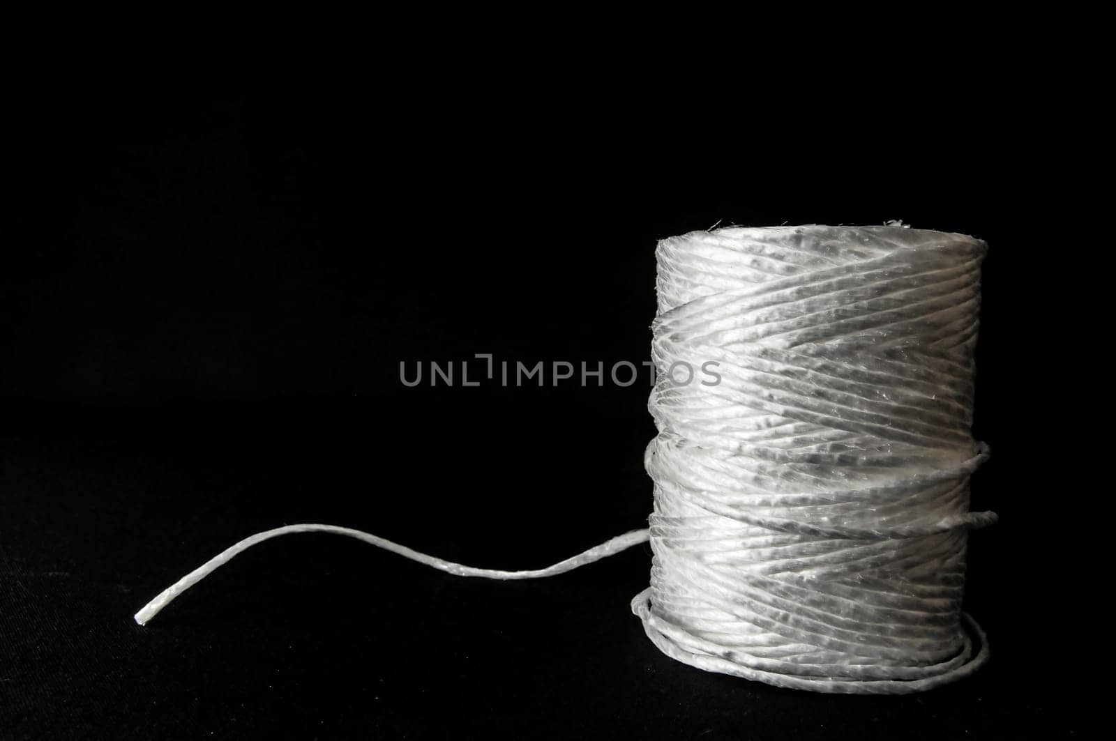 Roll of White Twine on a Black Background